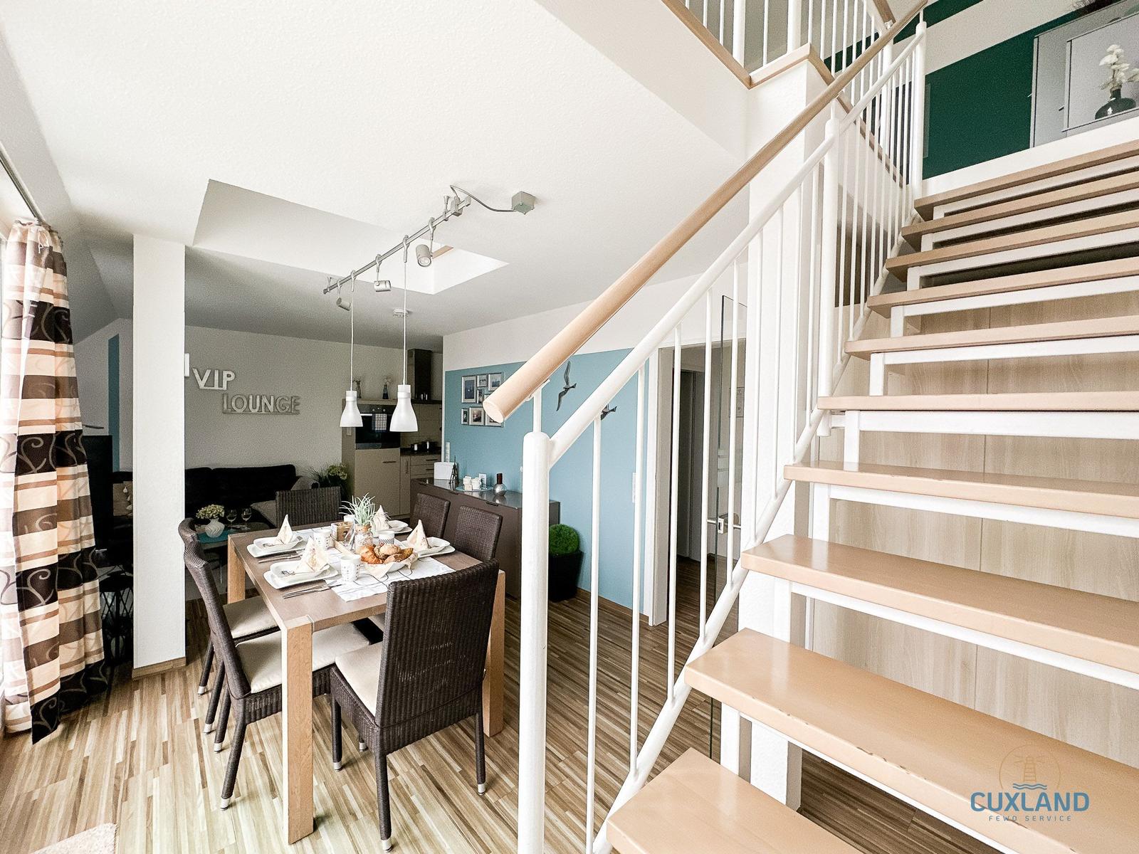Esszimmer mit Tisch und Stühlen, Treppe zur oberen Etage, Wand mit VIP LOUNGE Schriftzug