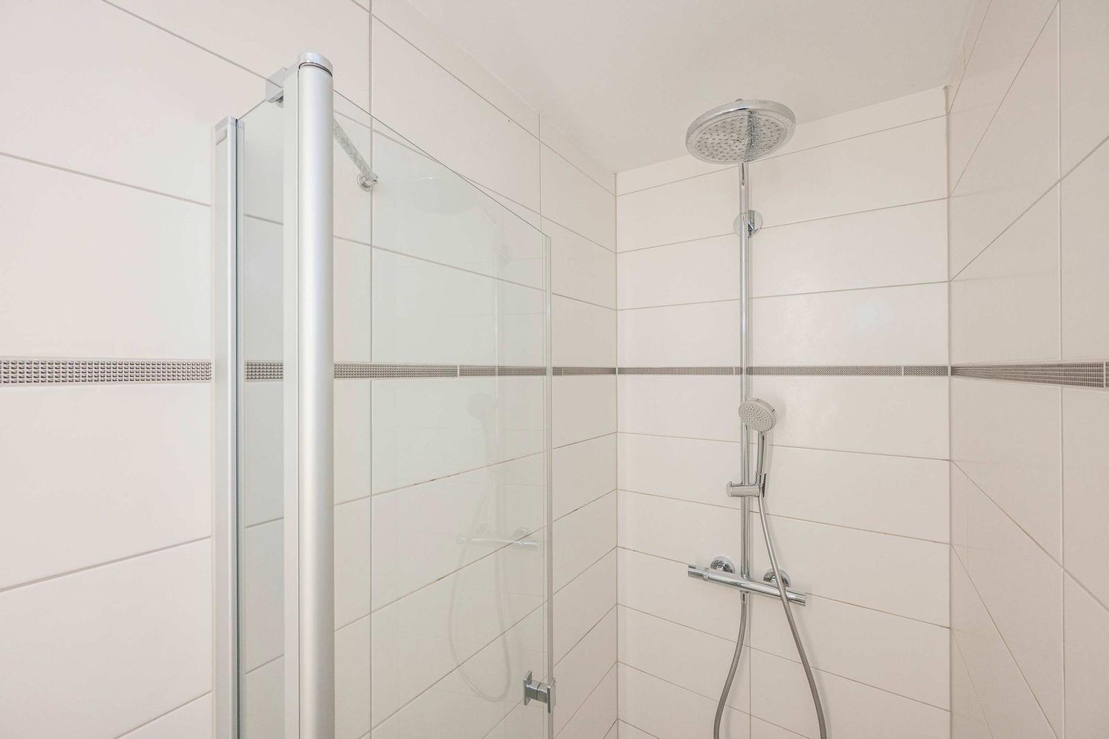Dusche mit Glaswand und Duschbrause