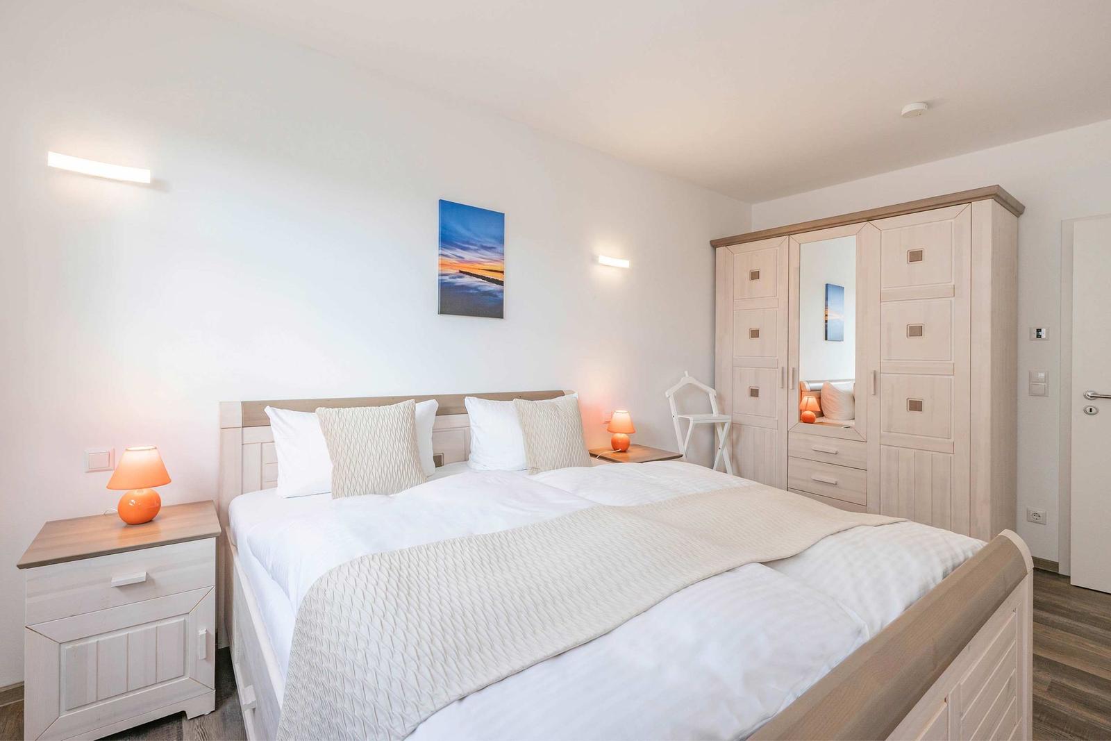 Bedroom with double bed, nightstands, and wardrobe.