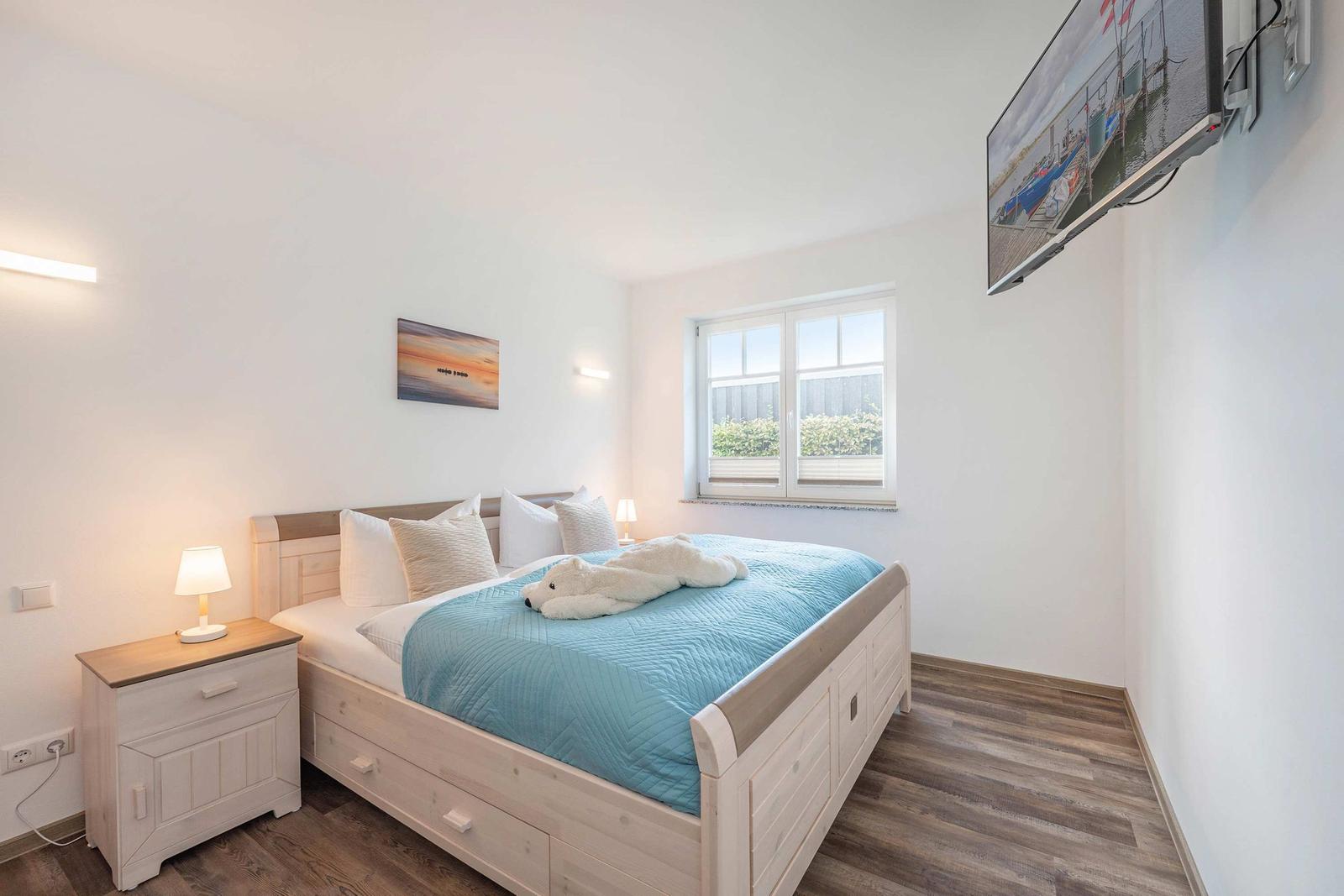 Bedroom with bed, nightstand, TV, and window