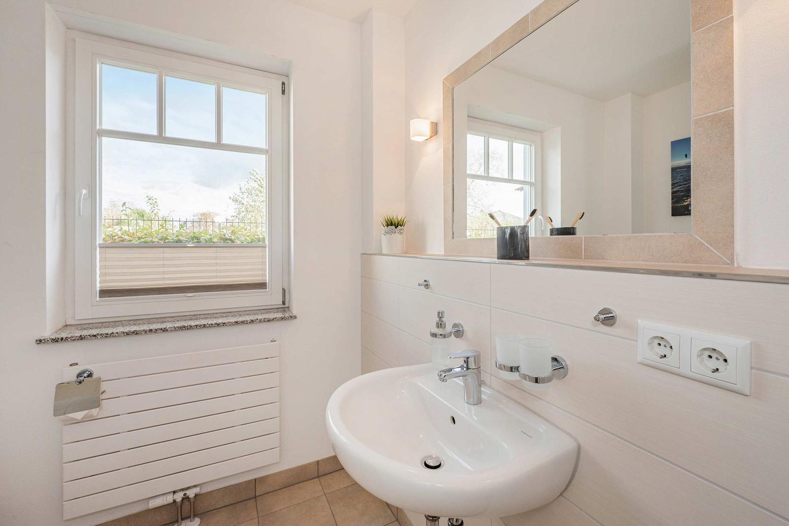 Bathroom with sink, mirror, and window for views.