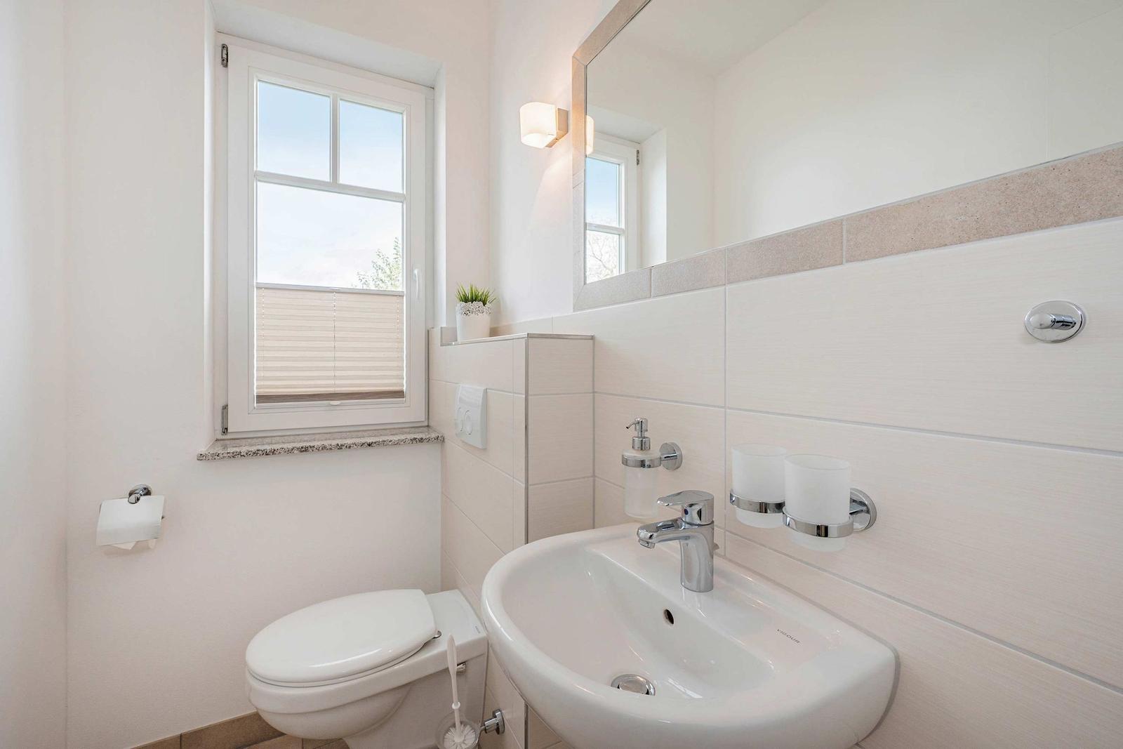 Bathroom with sink, toilet, and window.