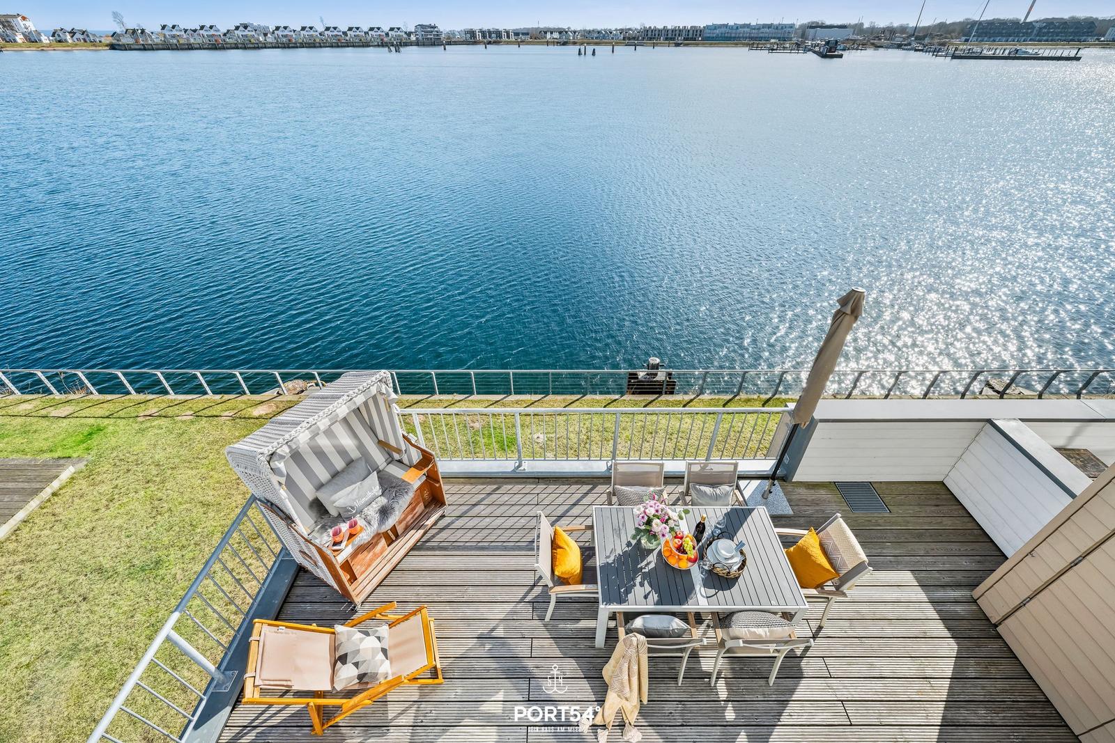 Terrasse mit Sitzgelegenheiten und Blick auf das Wasser