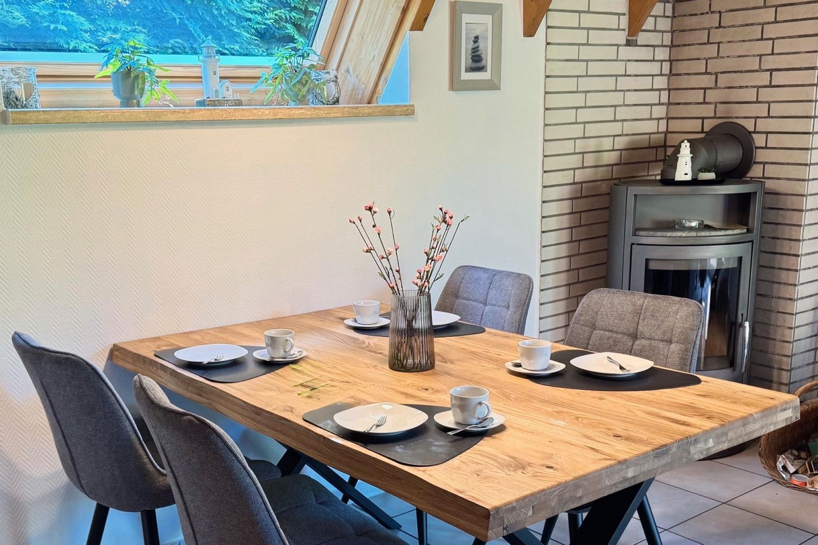 Wooden table with chairs, table decor, and fireplace in dining area.