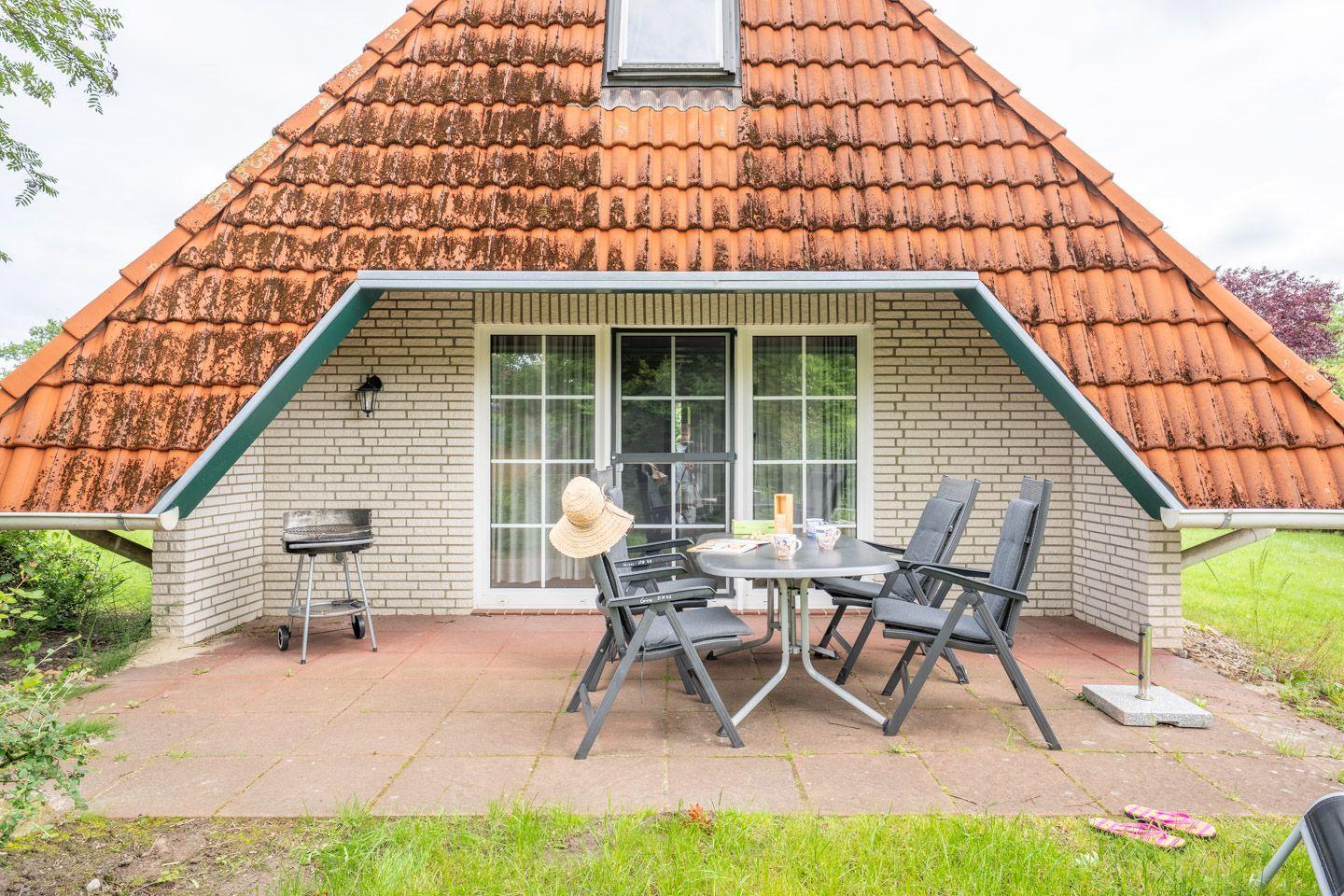 Haus mit Terrasse, Grill und Sitzgruppe unter Dach