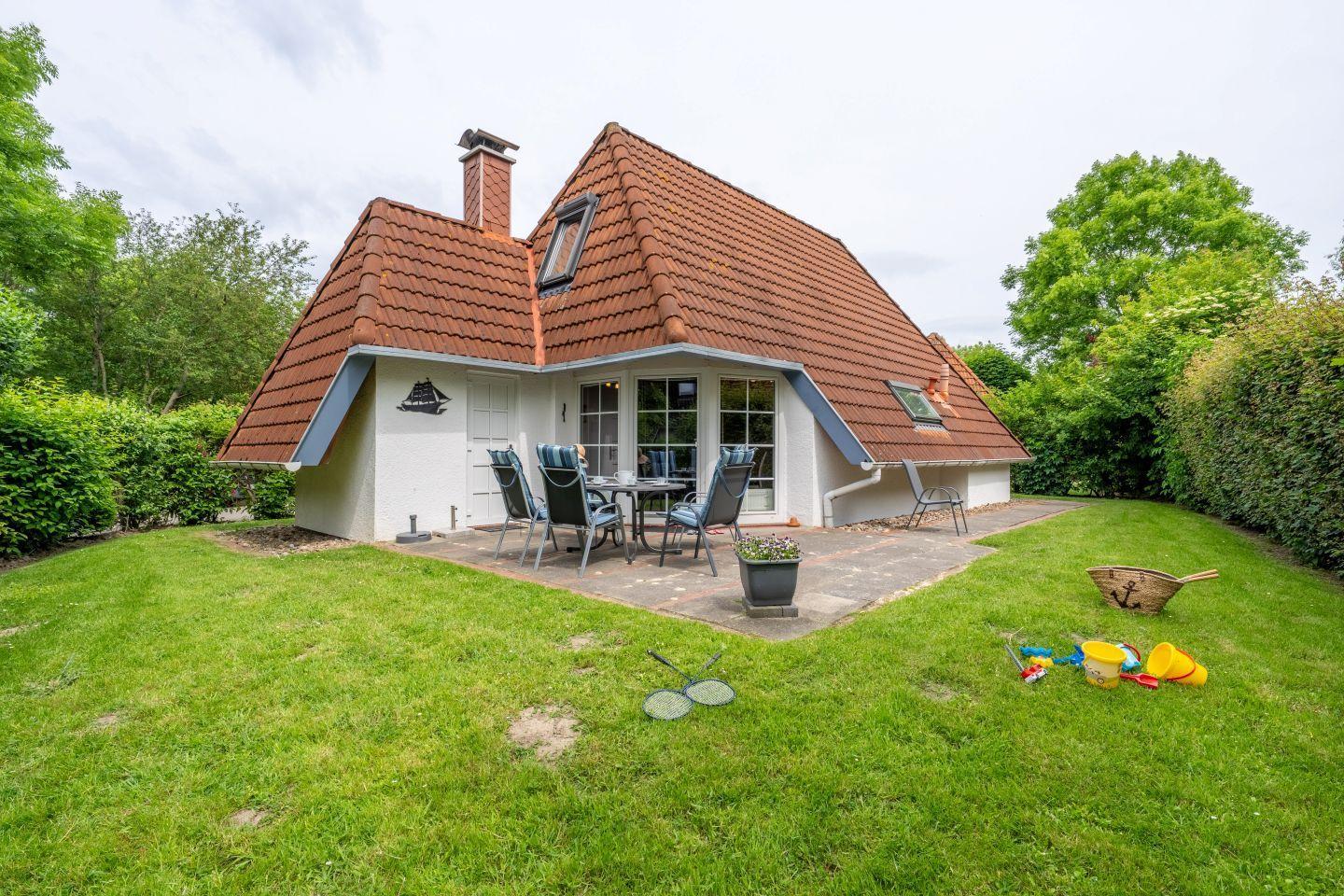 House with terrace, garden, and toys. Roof with tiles and window front.