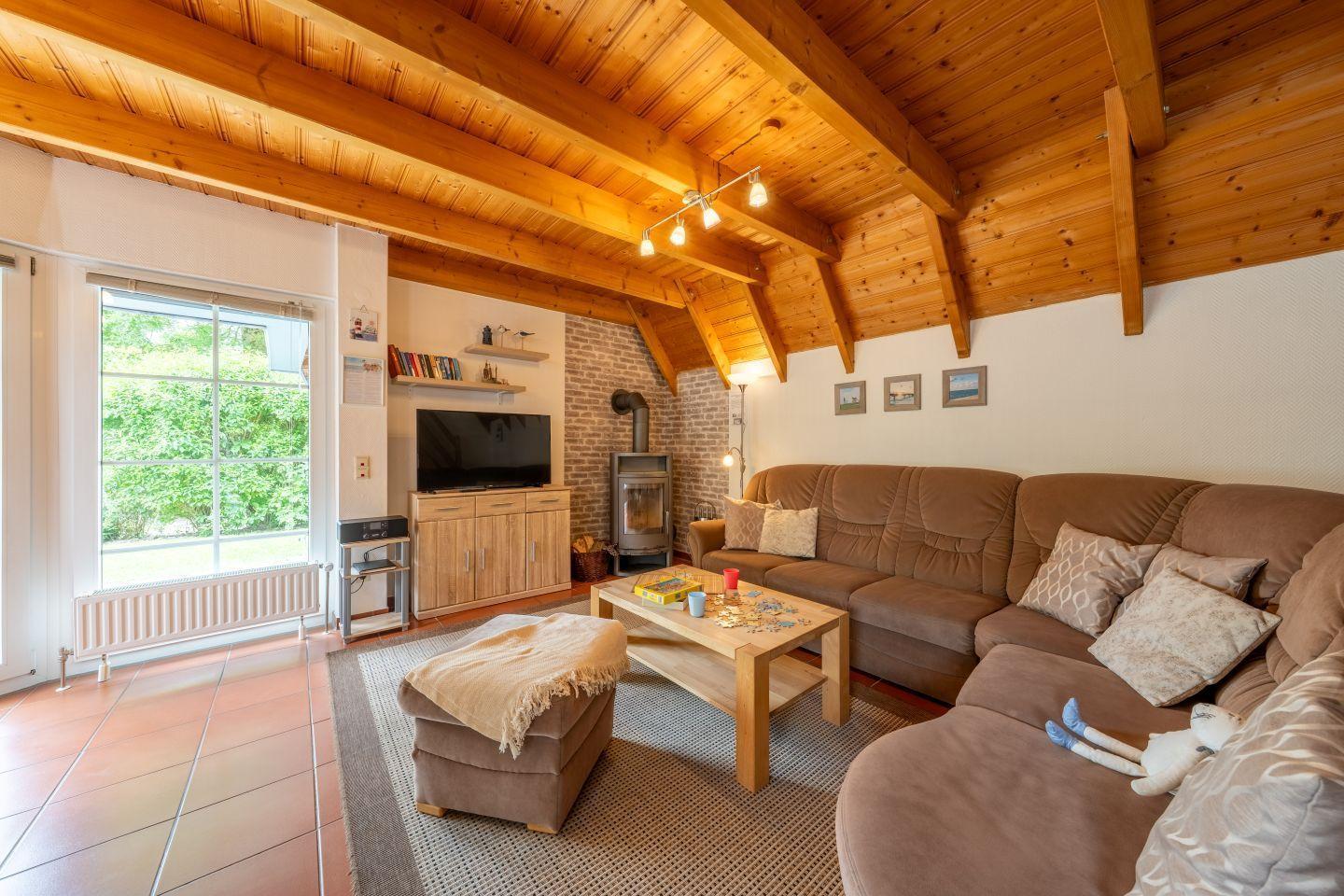 Living room with wooden ceiling, sofa, fireplace, and TV.
