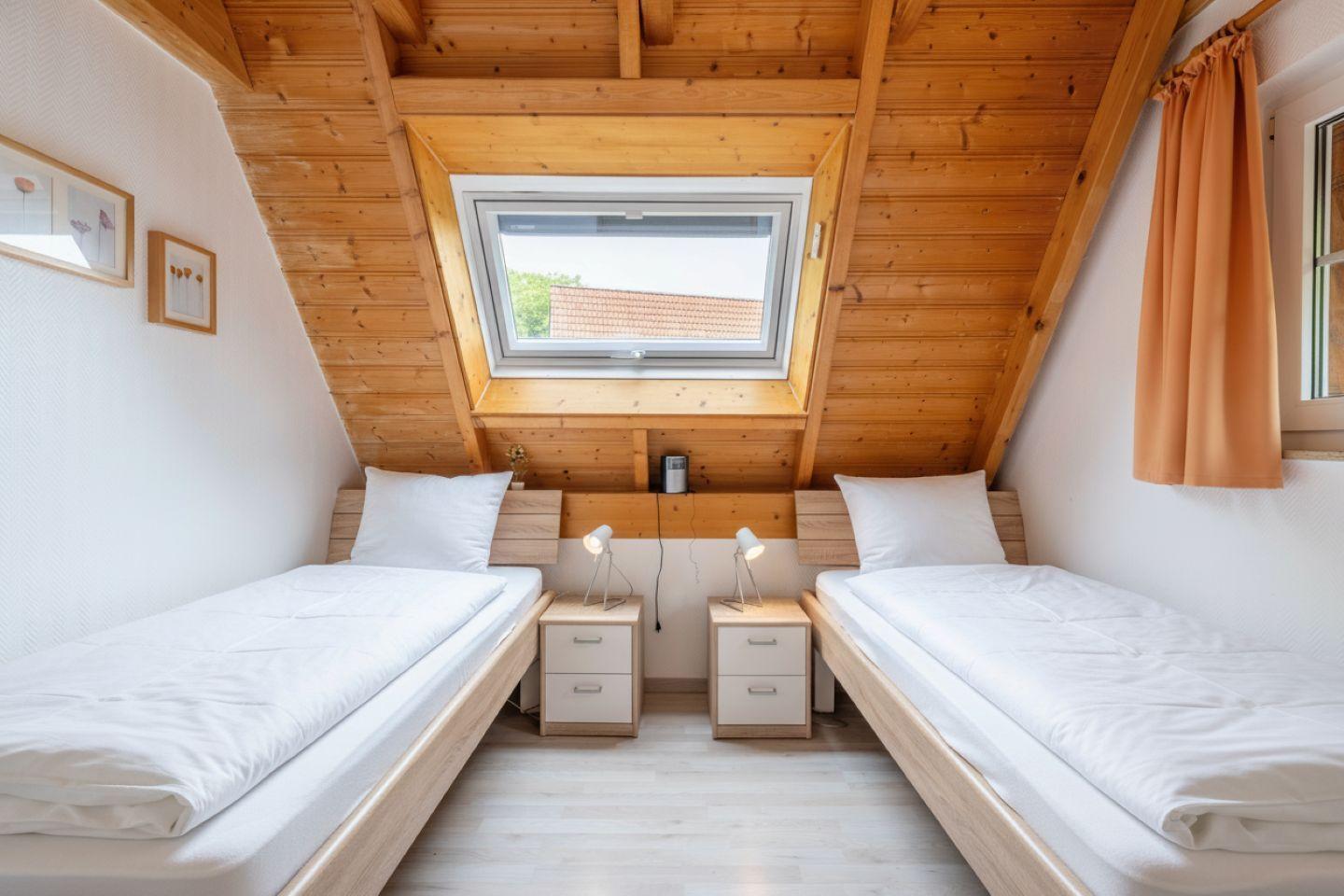 Two single beds under wooden roof with skylight and nightstands.