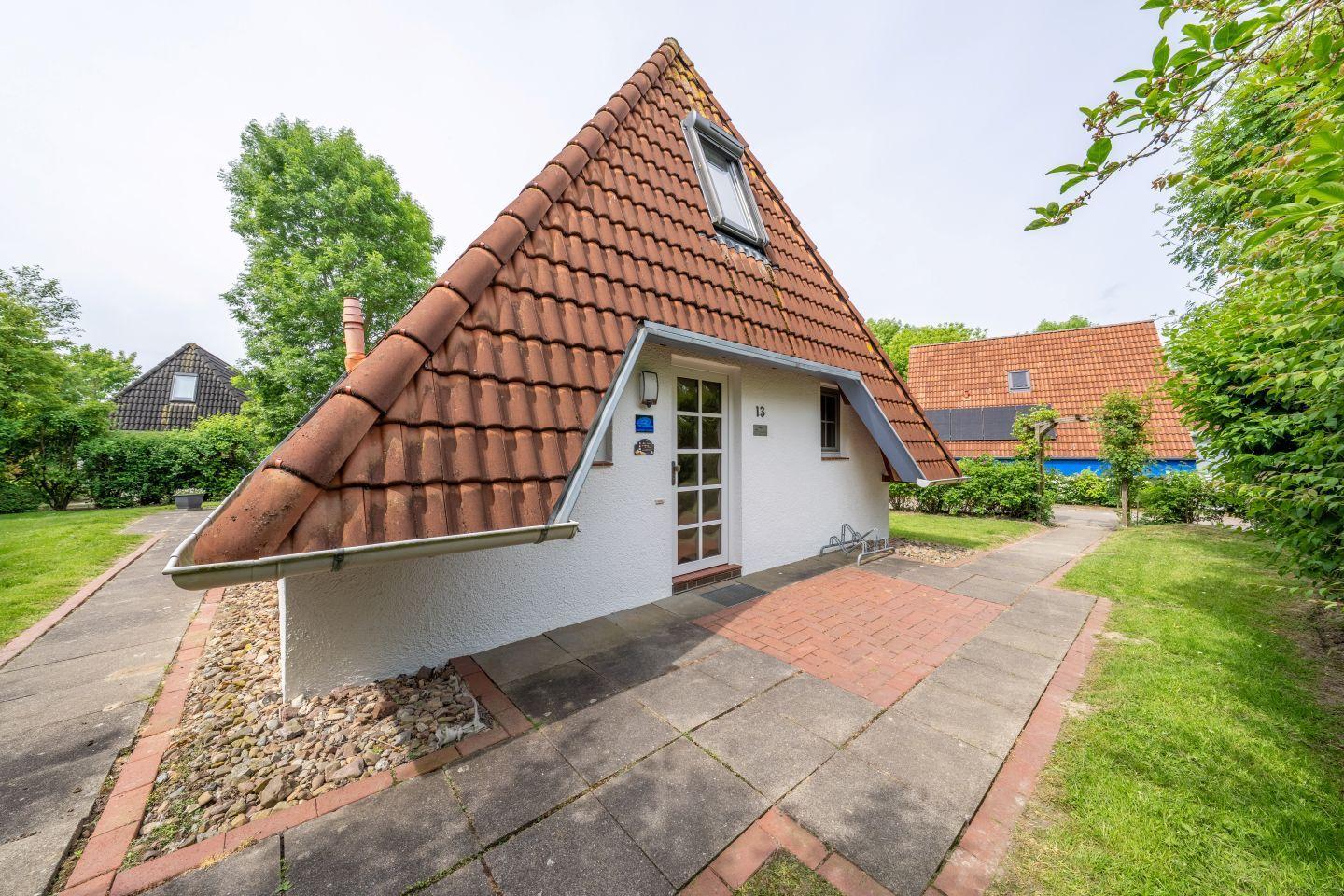 House with red tiled roof, white walls, and front garden