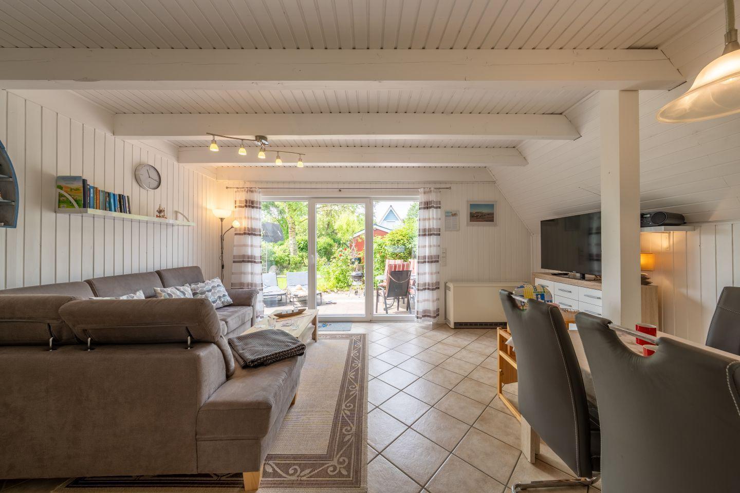 Living and dining area with sofa, TV, and terrace door