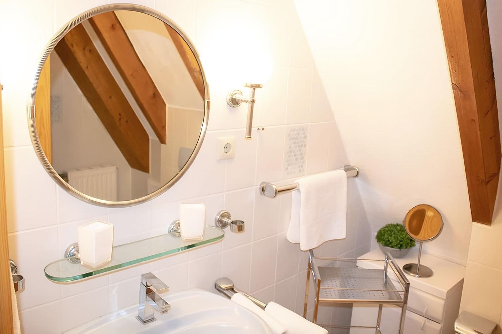 Badezimmer mit Spiegel, Waschbecken und Handtuchhalter