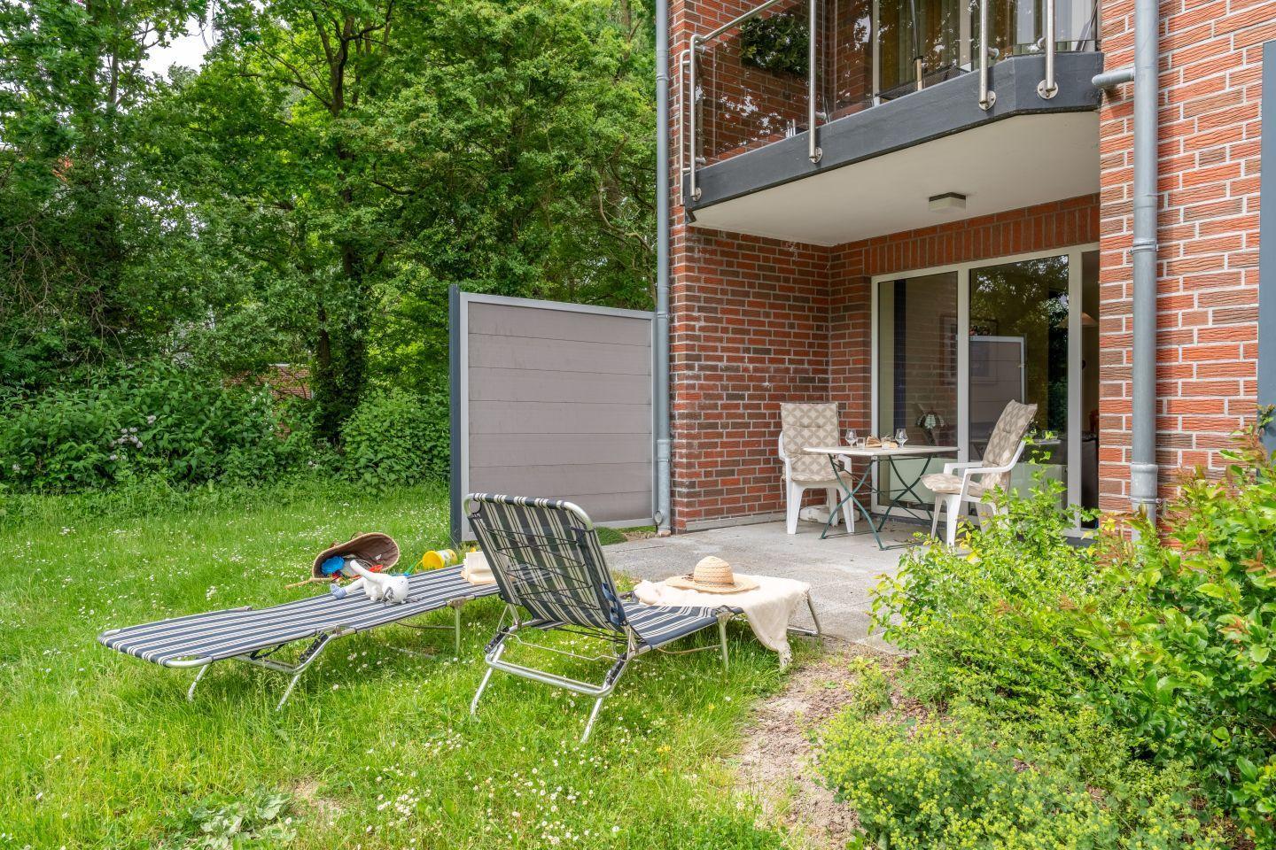 Backyard with loungers, terrace, and view of the house.