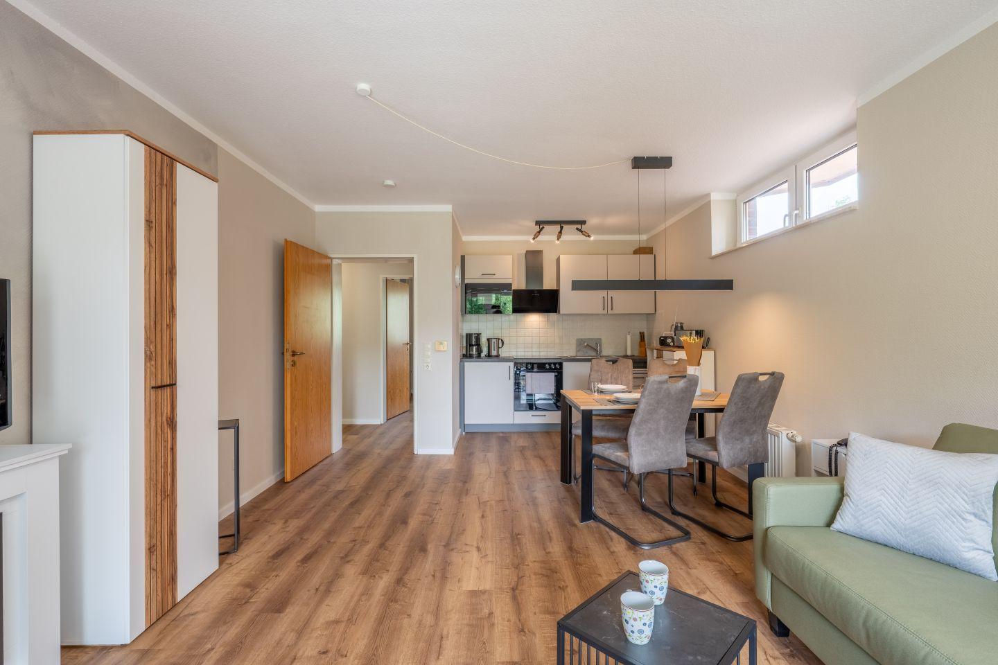 Wohnbereich mit Essbereich und Küche. Holzdielenboden und moderne Einrichtung.