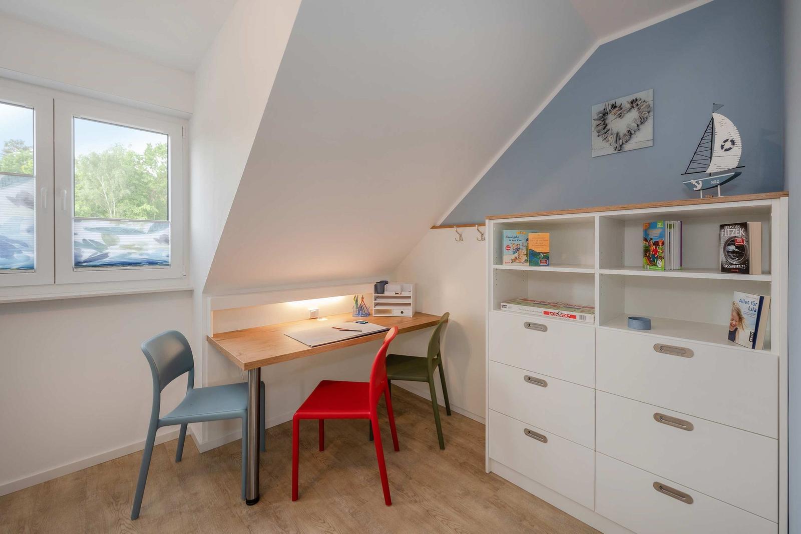 Ein Arbeitszimmer mit Schreibtisch, drei Stühlen und einem Bücherregal unter einem Dach