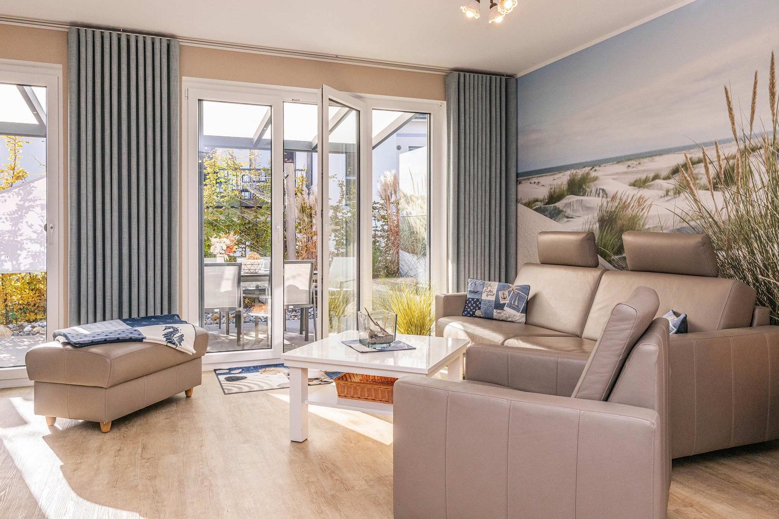 Wohnzimmer mit Sofa, Couchtisch und Glasfront zur Terrasse.