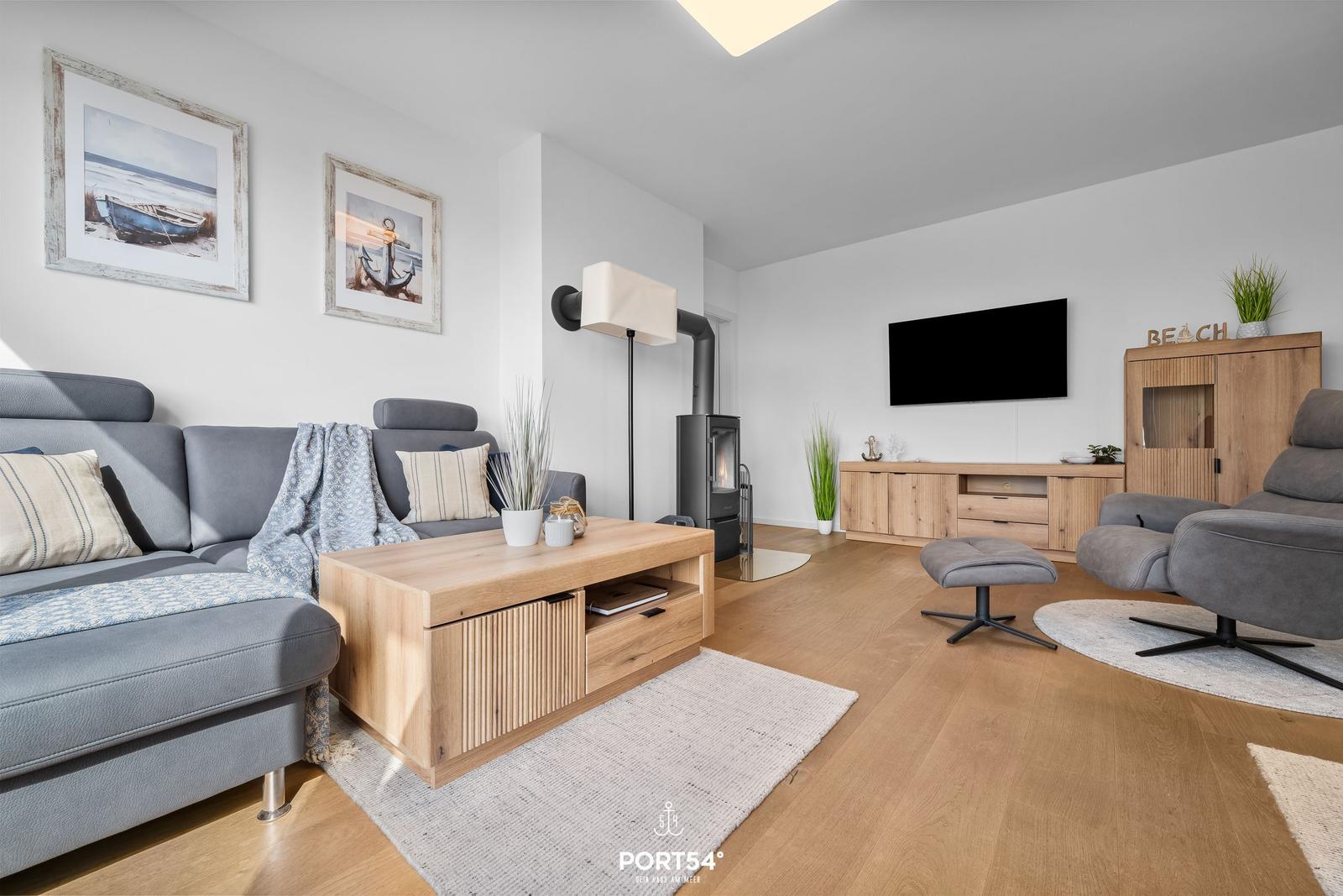 Wohnzimmer mit Sofa, Fernseher und Holzmöbeln.