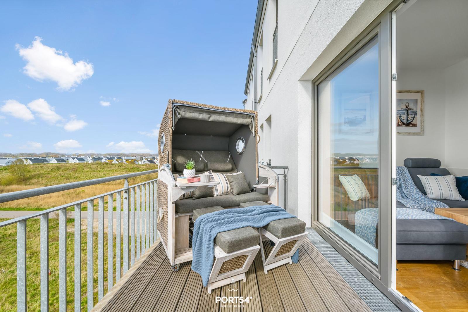 Terrasse mit Strandkorb und Blick auf Grünland und Häuser