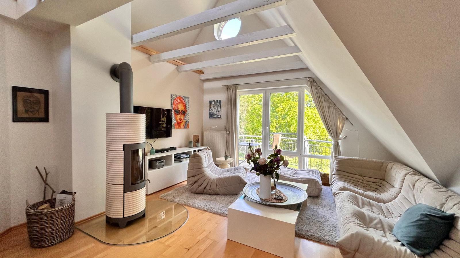 Wohnzimmer mit Kamin, Sofa und Blick auf Balkon