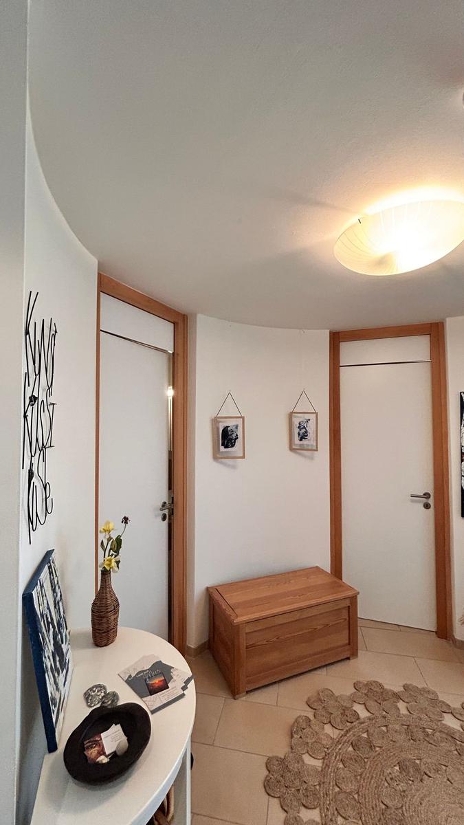 Eingangsbereich mit Holztruhe, zwei Türen und dekorativen Elementen an der Wand.