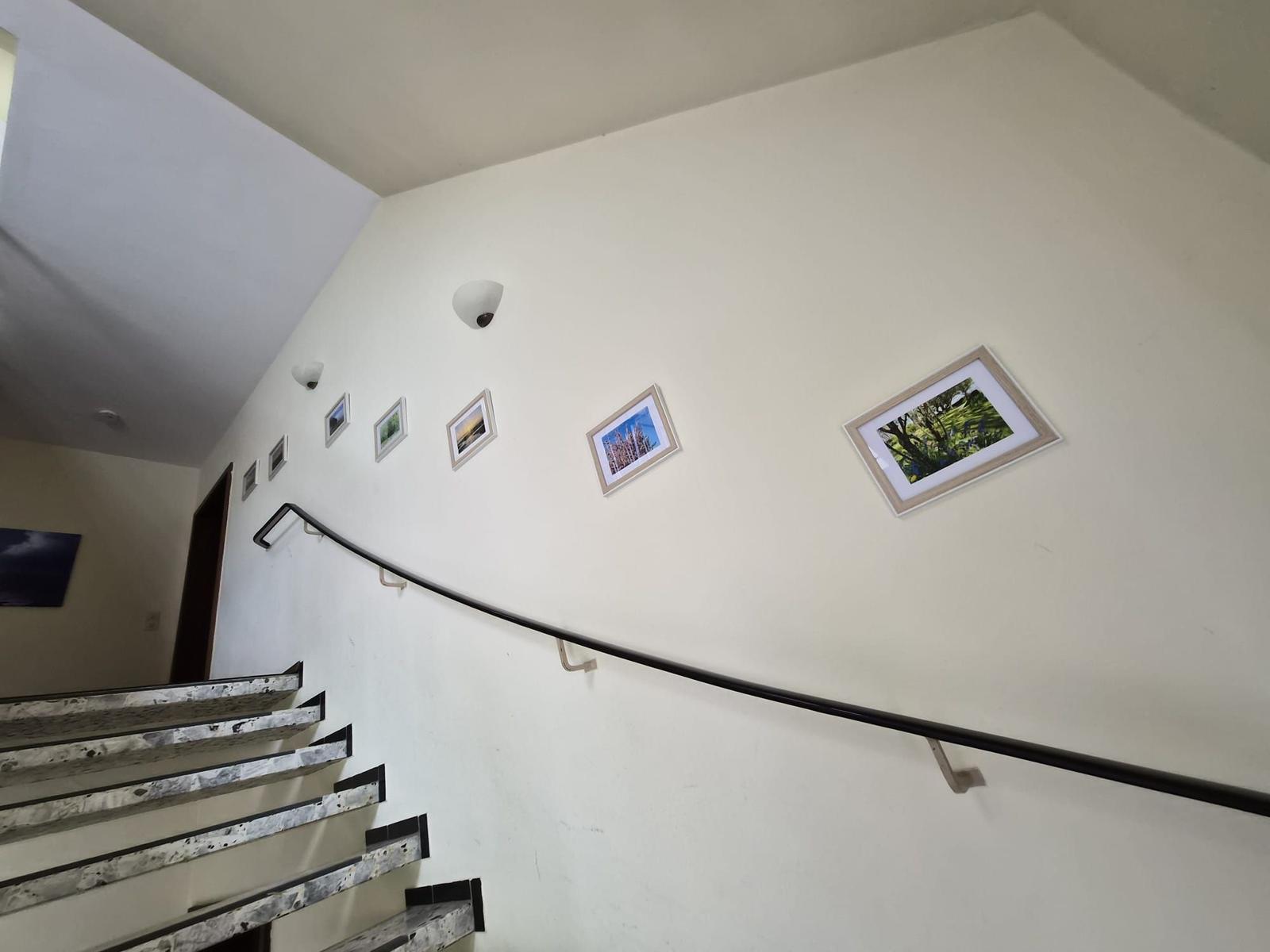 Treppe mit Geländer und Bildern an der Wand.