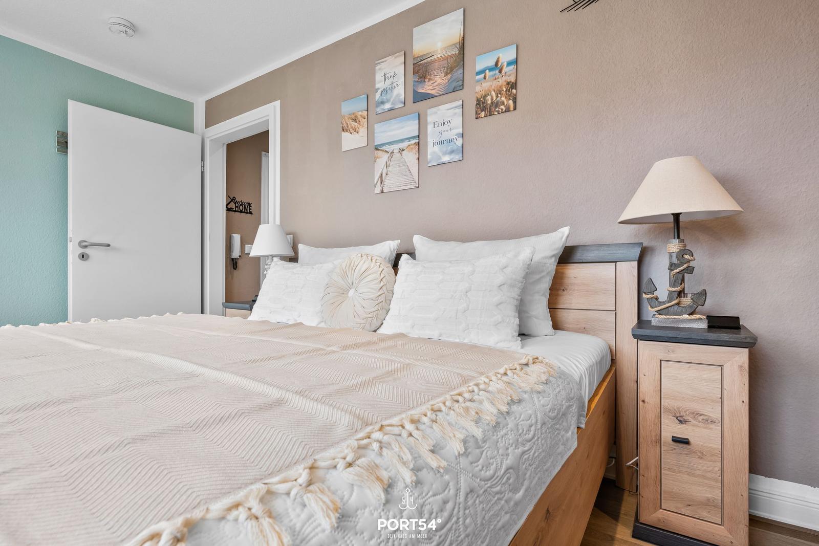 Schlafzimmer mit Bett, Nachttisch und Wandbildern