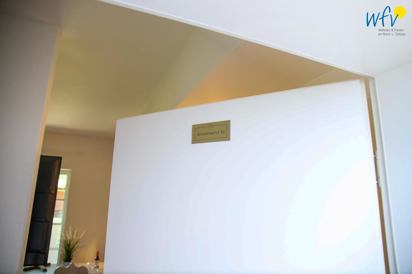 Türaufnahme mit Schild Appartement 16 an weißer Tür.