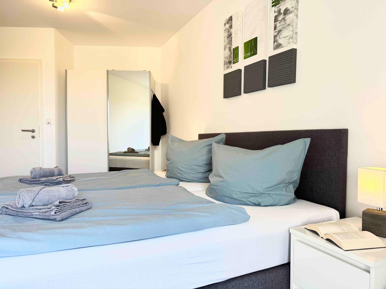 Ein Schlafzimmer mit Bett, Nachttisch und Wandbildern.