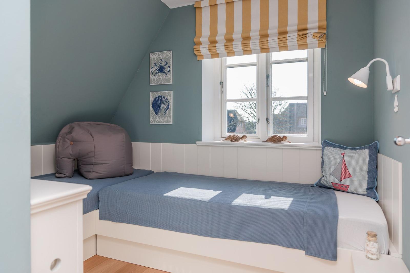 Ein Schlafzimmer mit Bett, Fenster und Wandbildern.