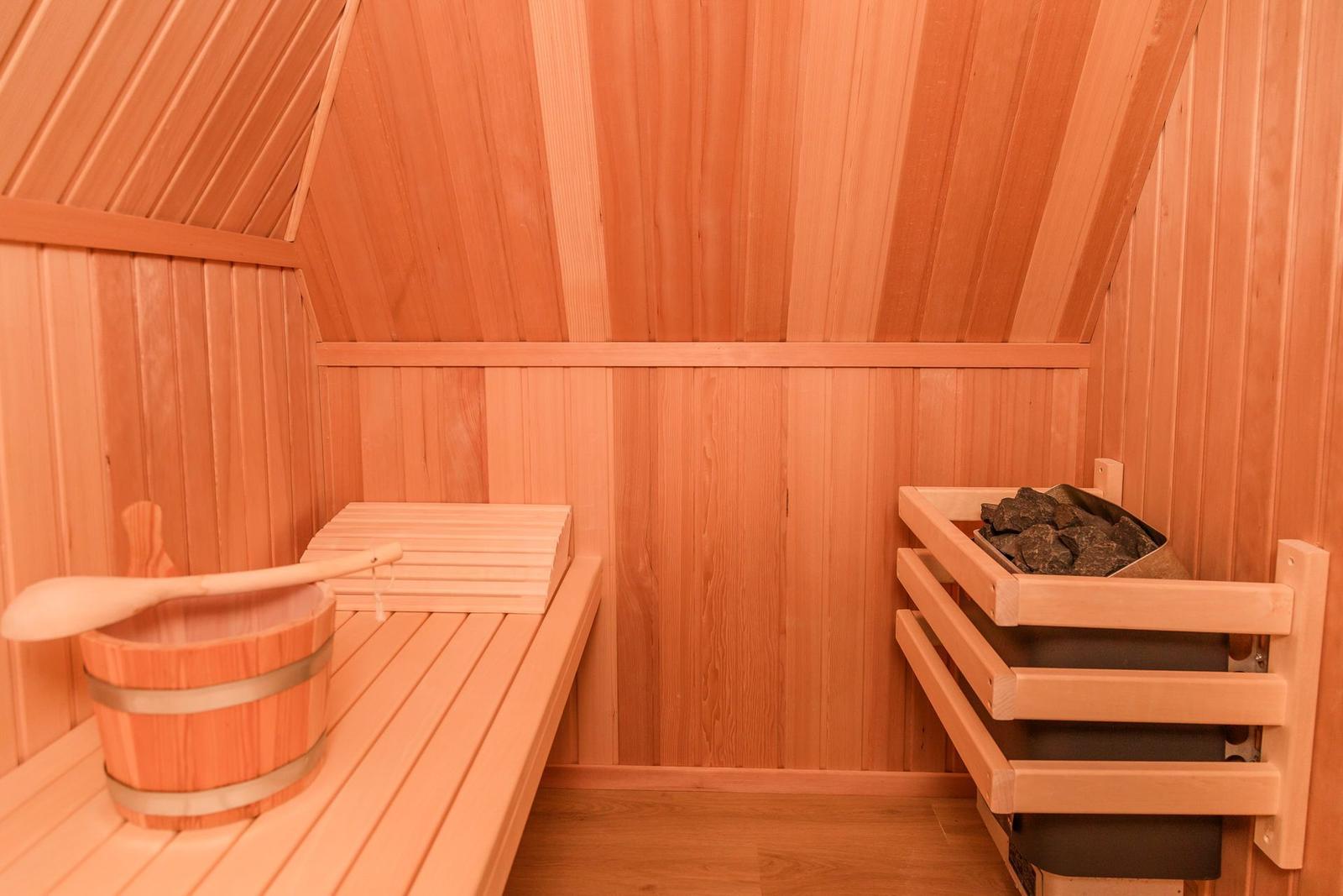 Sauna mit Holzbank, Eimer und Steinregal