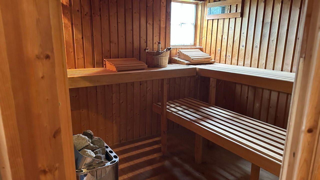 Sauna mit Holzbanken, Steinbehälter und Fenster