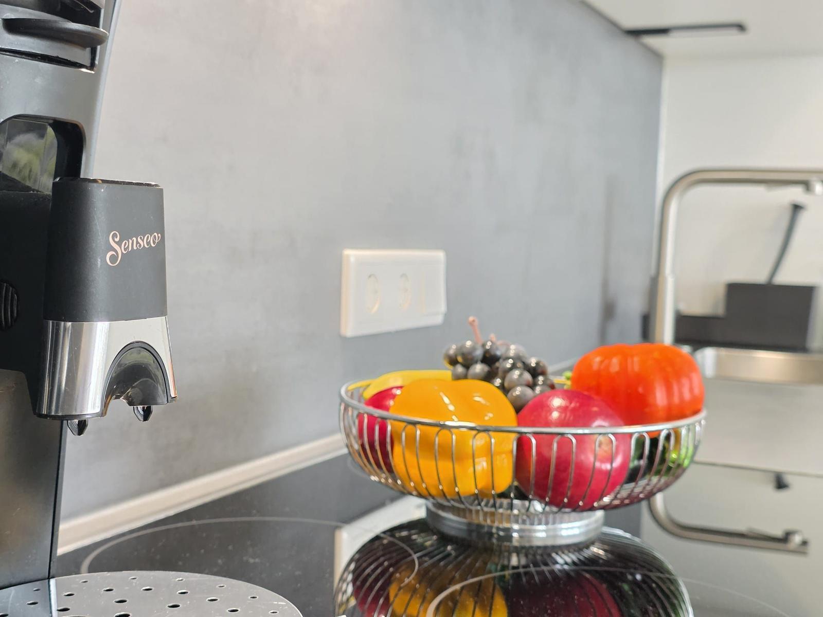 Küchenbereich mit Obstschale und Kaffeemaschine auf Arbeitsfläche