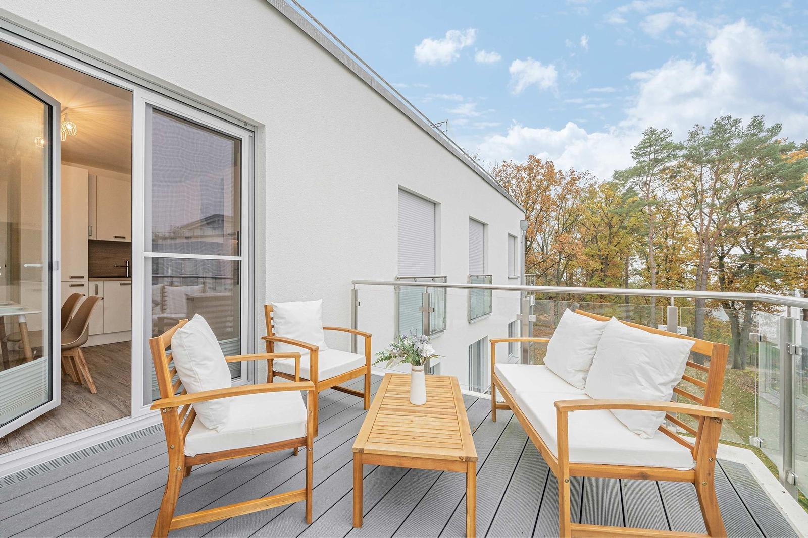 Terrasse mit Holzmöbeln und Blick auf Bäume