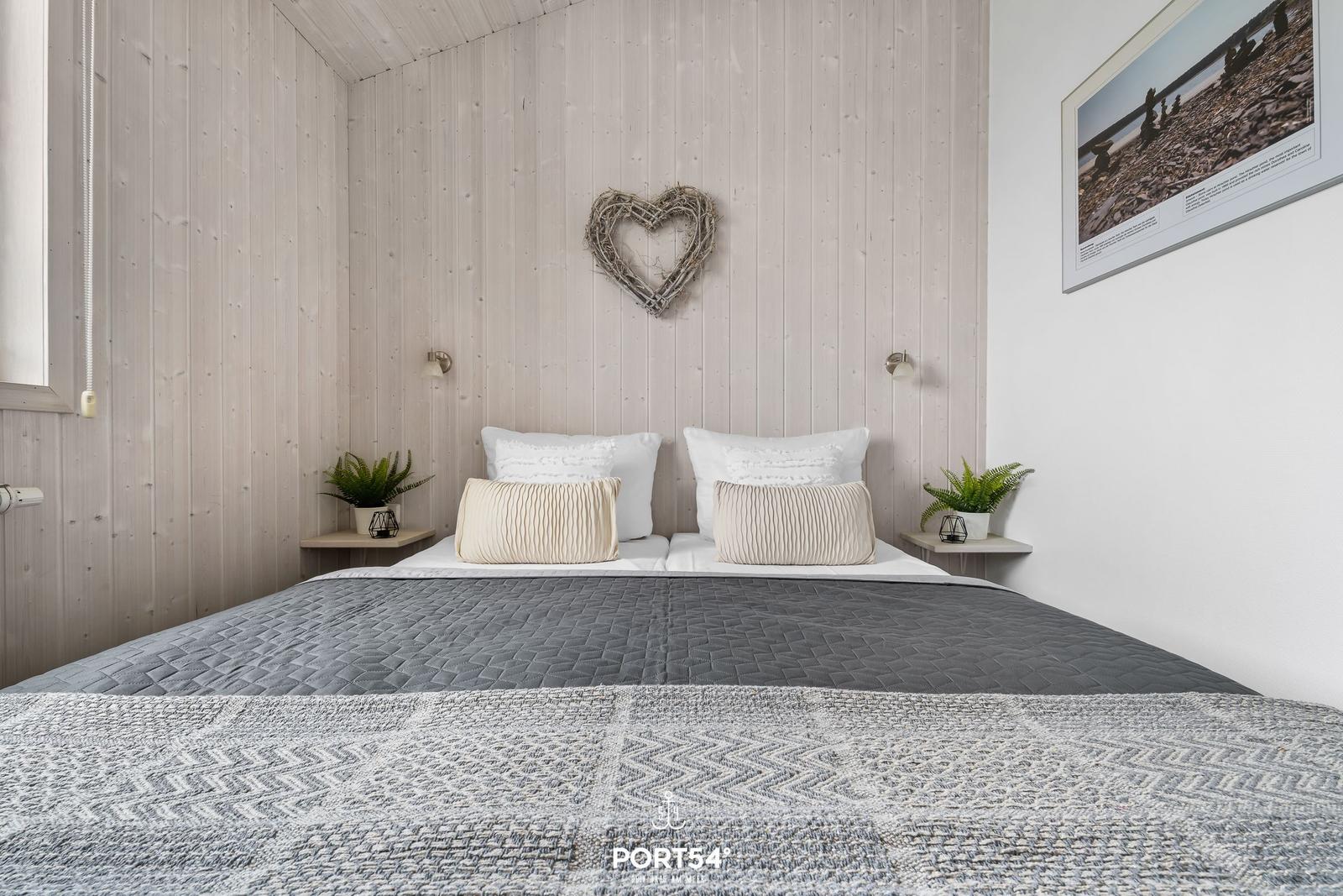 Bedroom with bed, wooden wall, and wall decor.