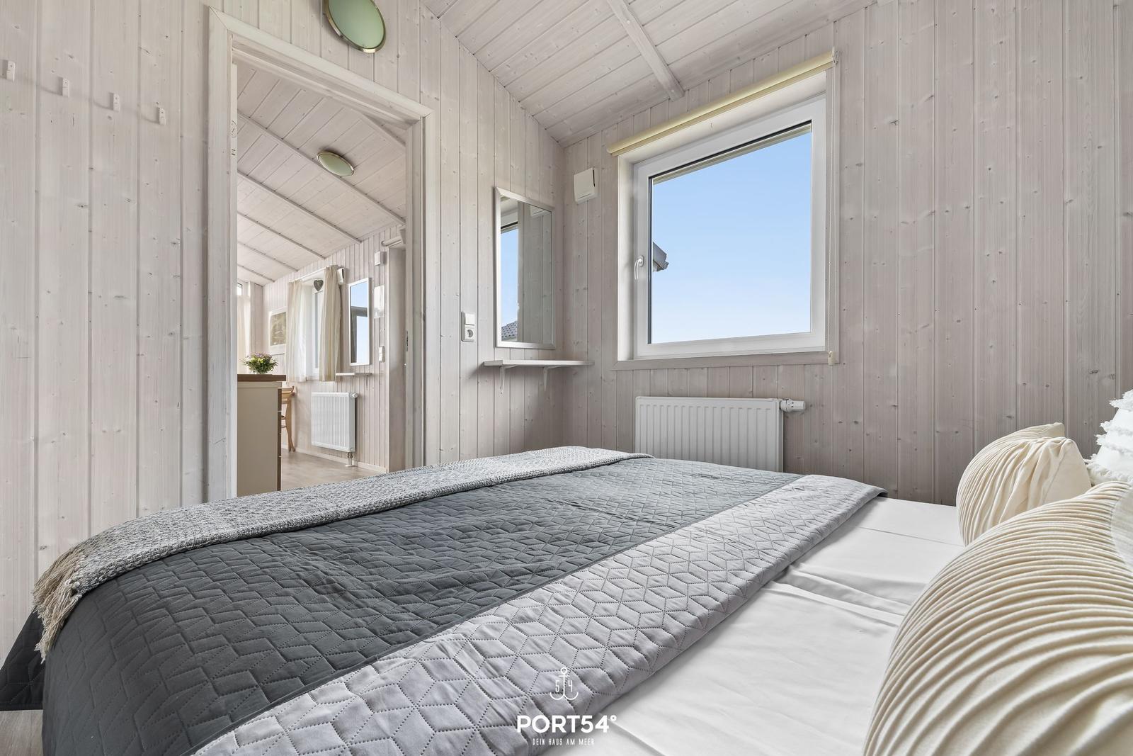 Bedroom with bed, window, and view into the hallway.