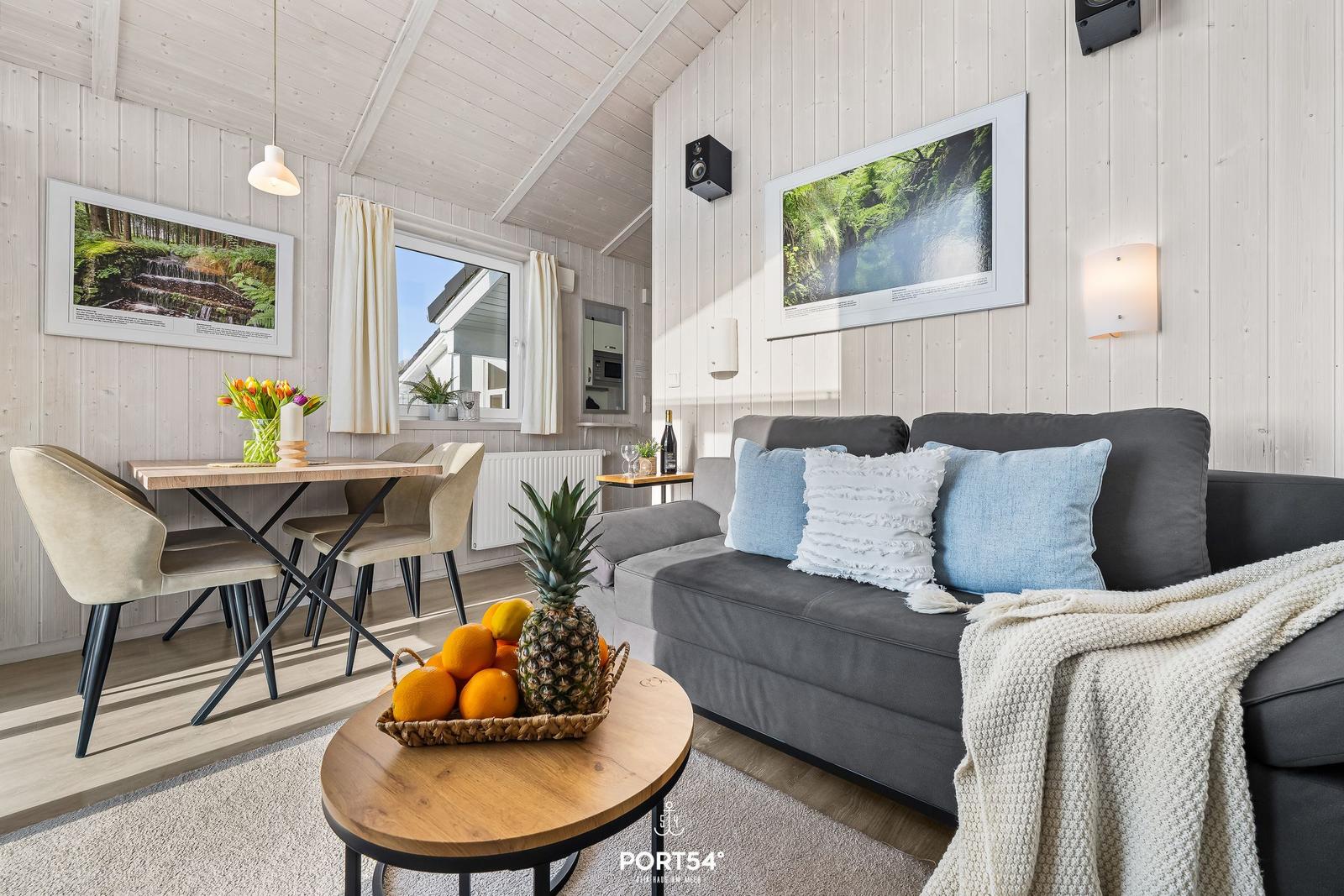 Living and dining area with sofa, table, and wall pictures.