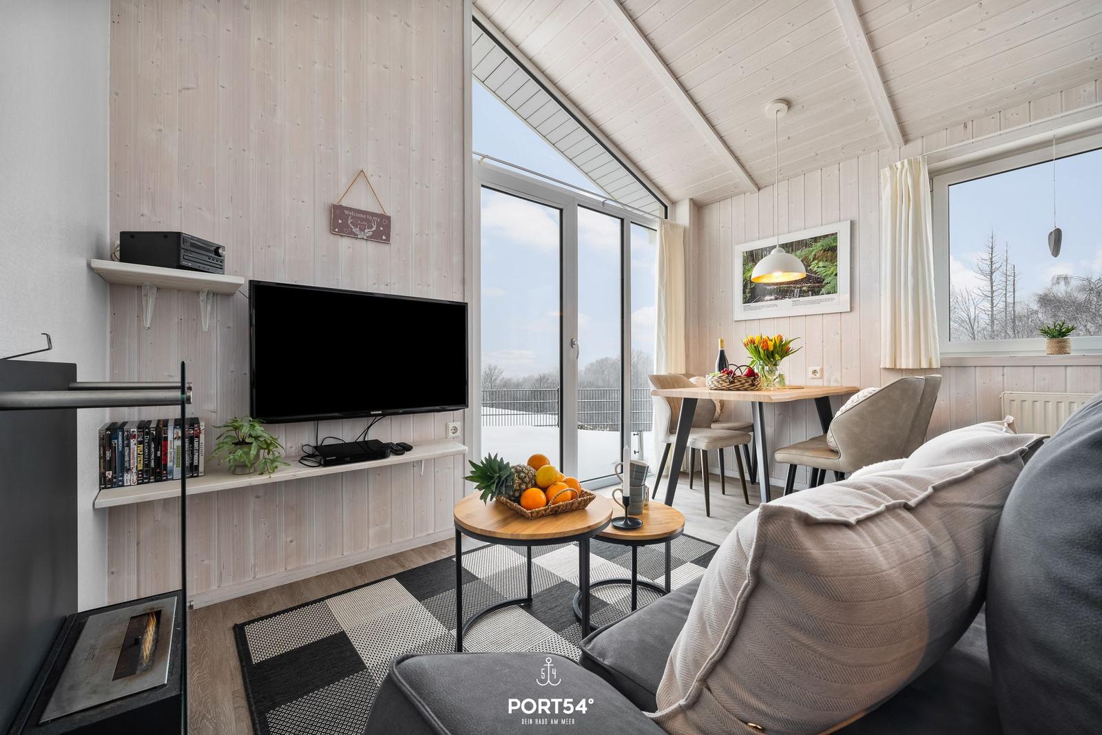 Wohnzimmer mit TV, Sofa, Esstisch und Blick auf Balkon
