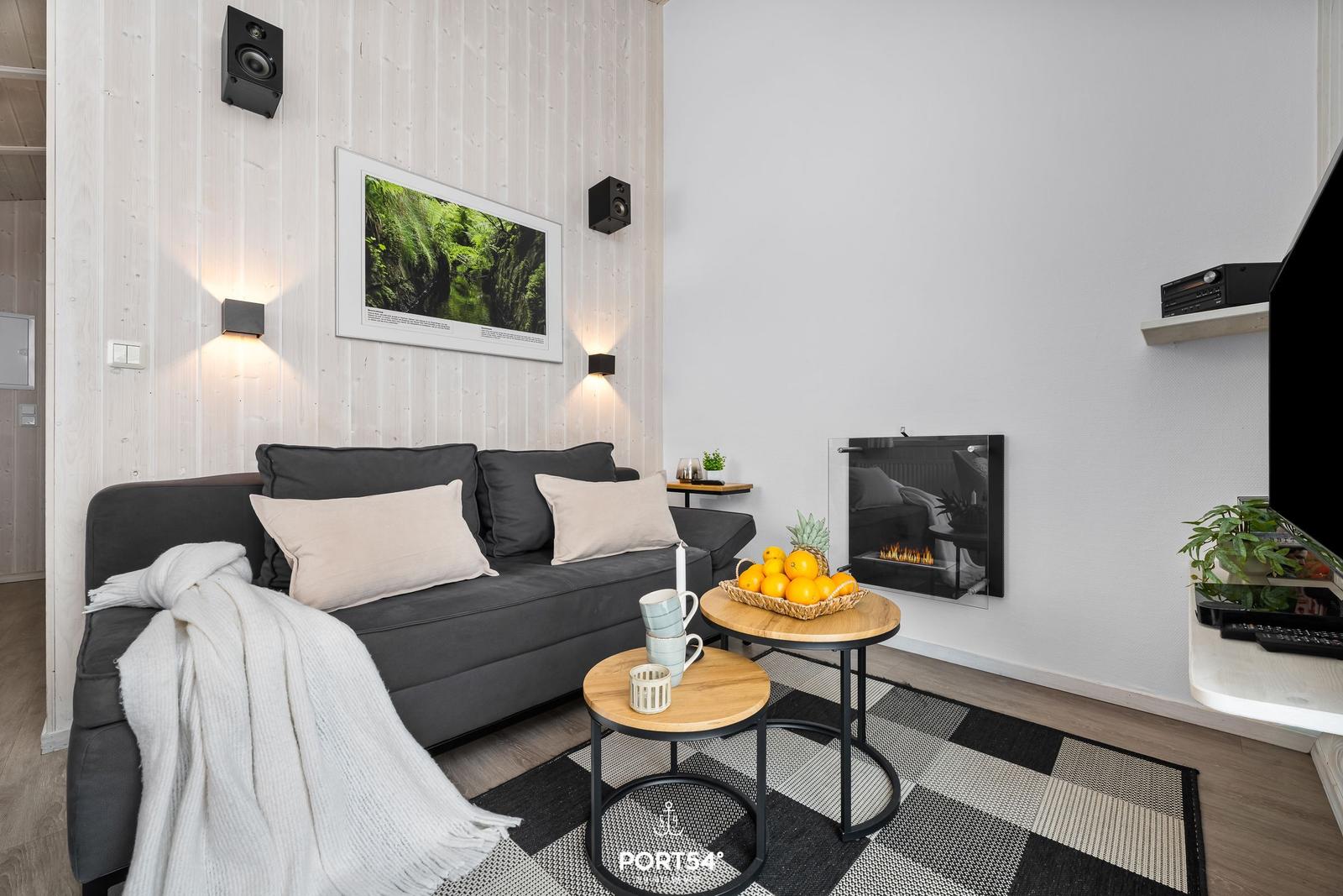 Ein Wohnzimmer mit Sofa, Kamin und Tisch mit Obst.