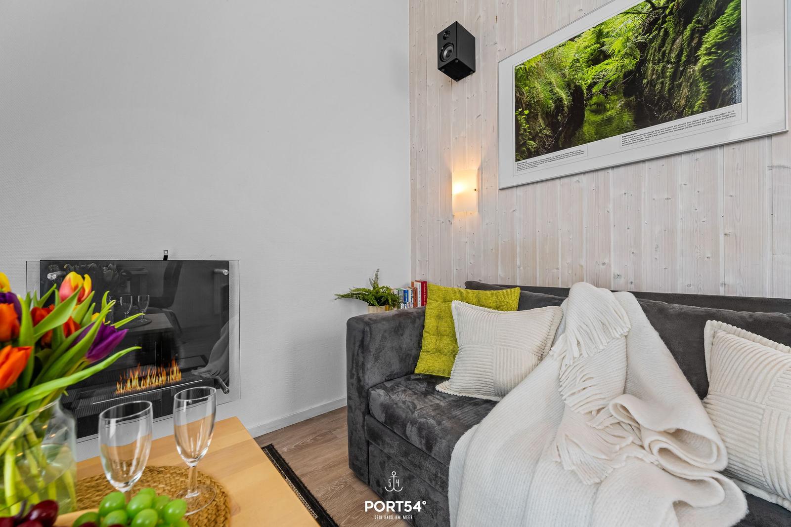 Ein Wohnbereich mit Sofa, Kamin und Wandbild.