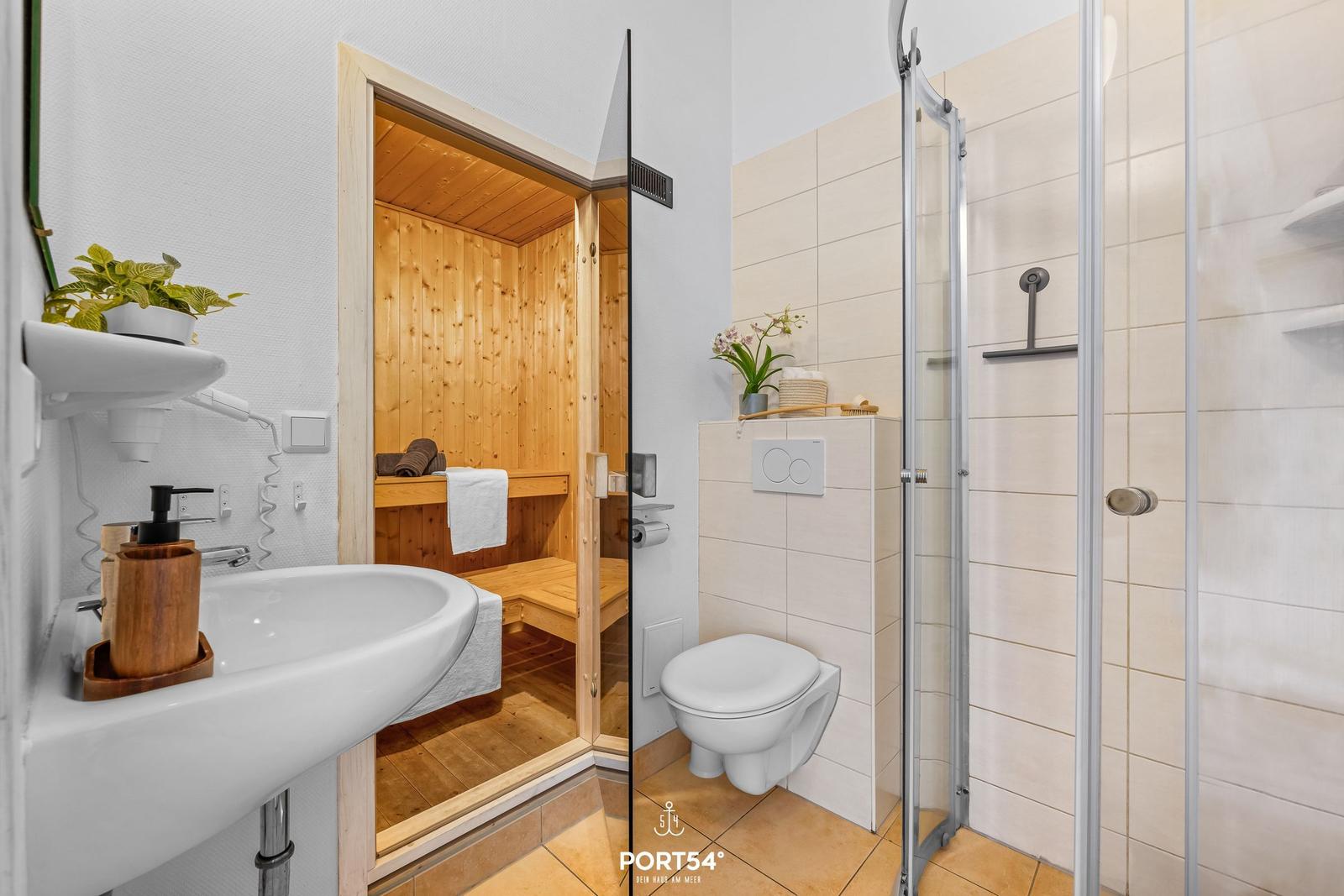 Badezimmer mit Dusche, Toilette und integrierter Sauna.