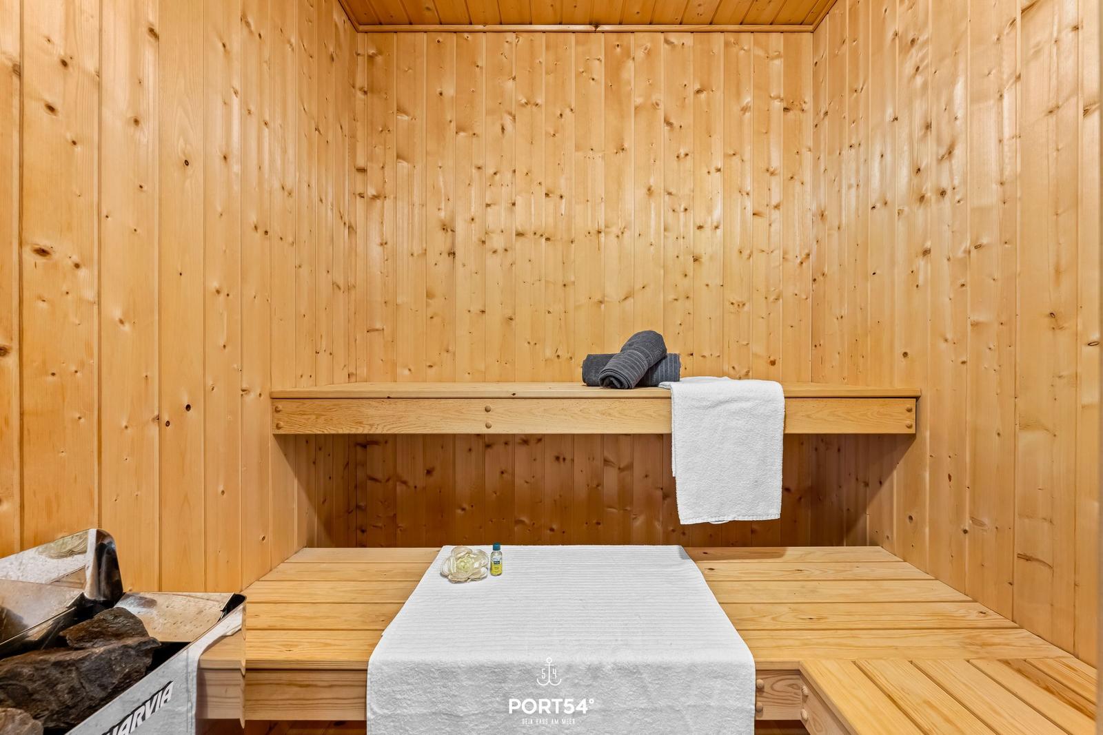 Sauna mit Holzwand, Bank und Handtuch