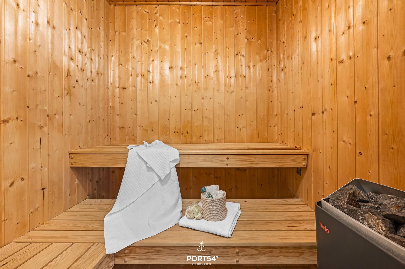 Sauna with wooden walls, bench, and bath accessories.