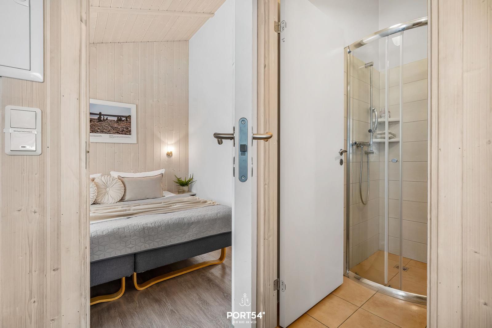 Bedroom with bed and shower in adjoining room