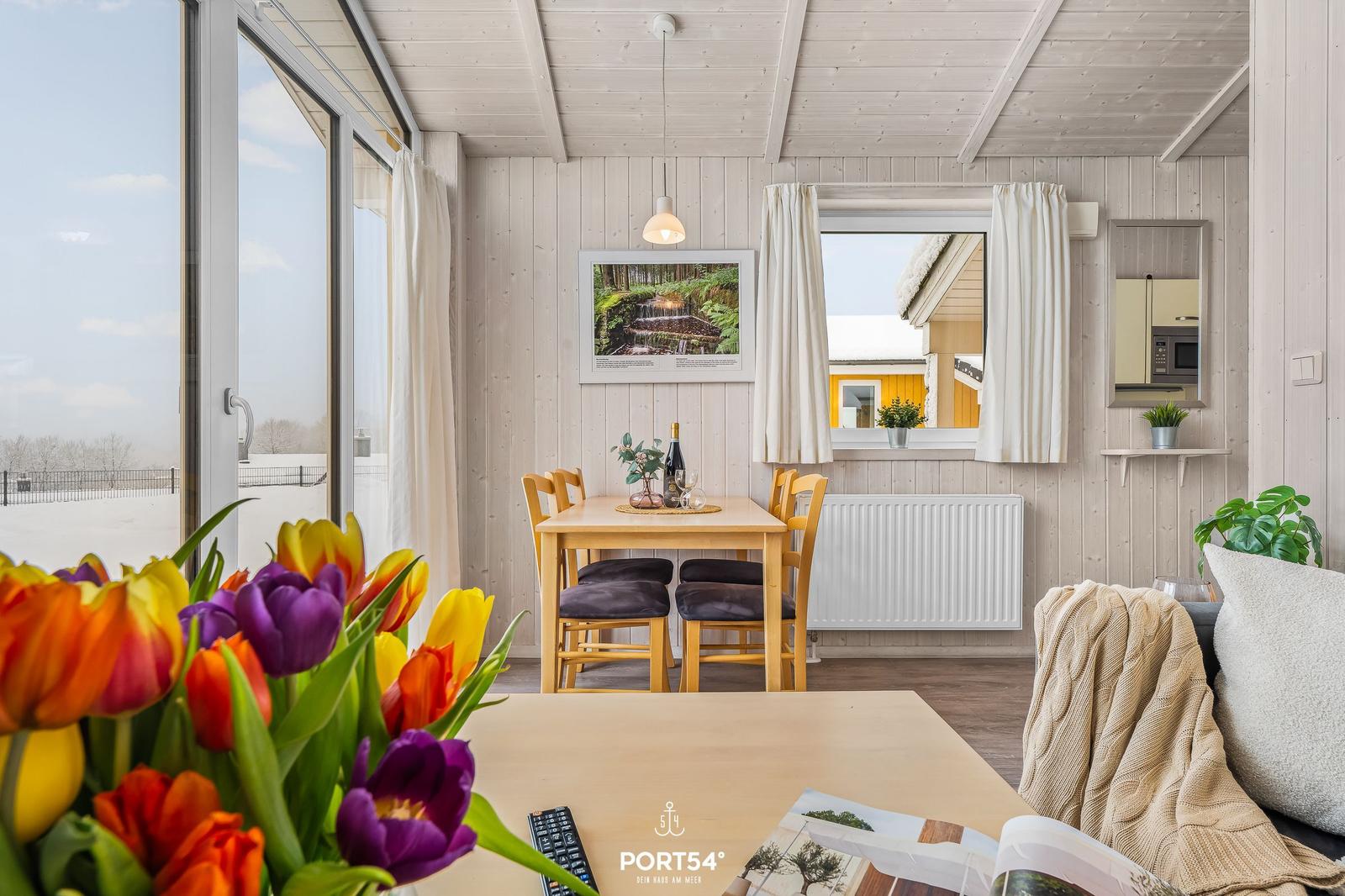 House with dining area, windows, and tulips in the foreground.