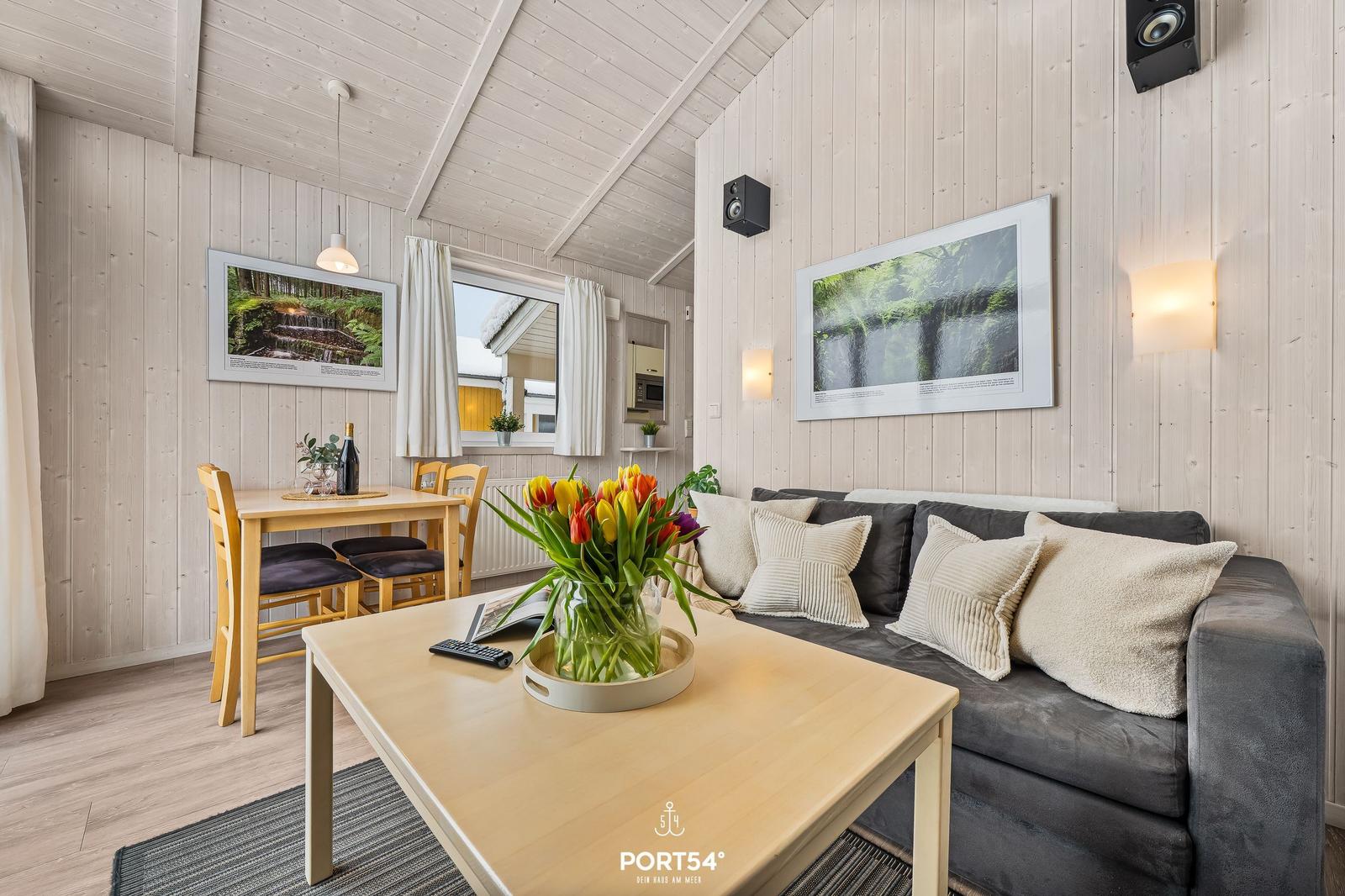 Living and dining area with sofa, table, and wall pictures.