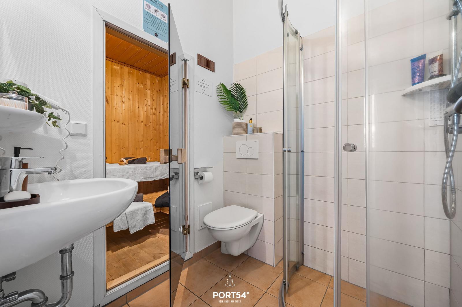 Bad mit Dusche, WC und Blick in die Sauna.