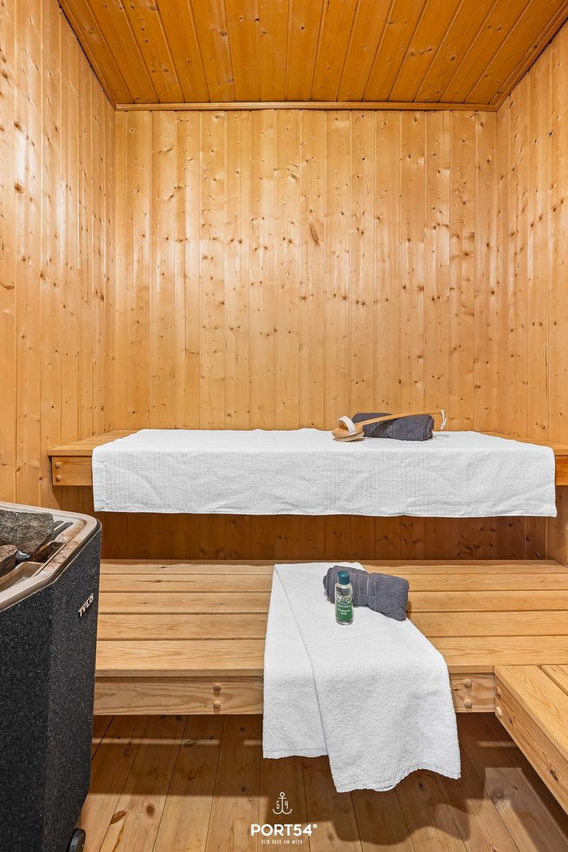 Sauna mit Holzwand, Liegefläche und Handtuch.
