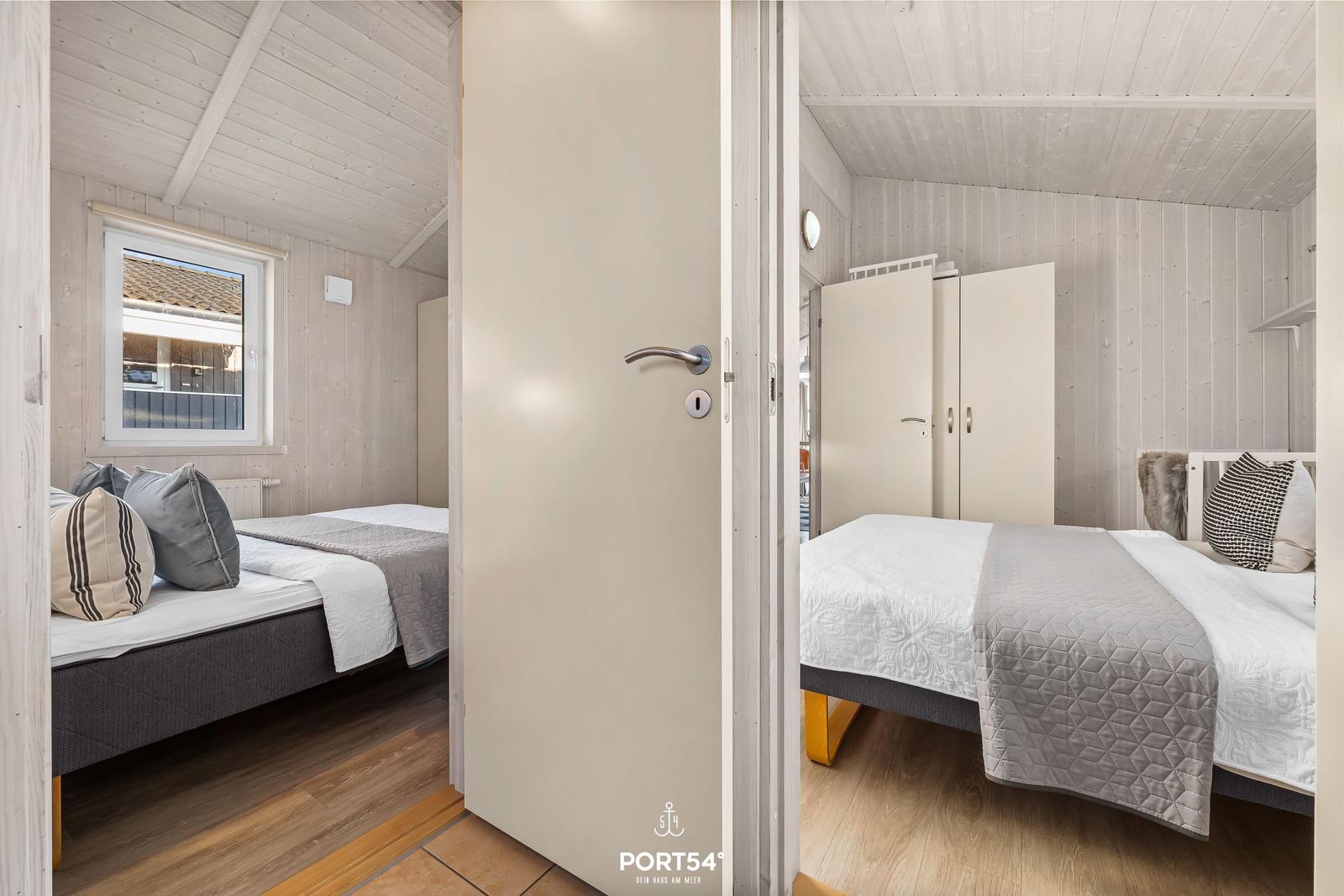 Zwei Schlafzimmer mit Betten, Kleiderschränken und Fenstern. Holzwände und Boden.