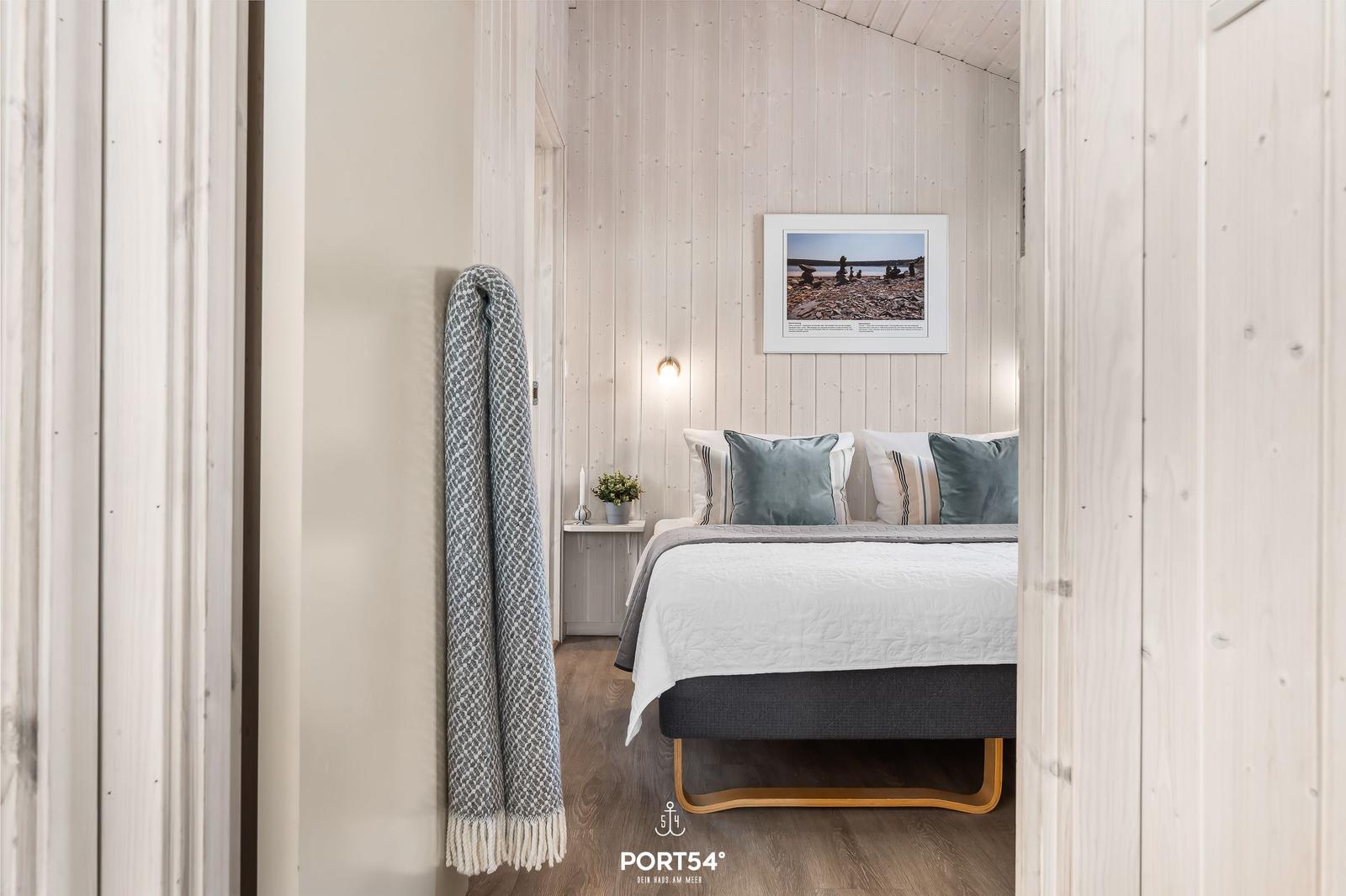 Schlafzimmer mit Bett, Wandbild und Decke an der Wand.