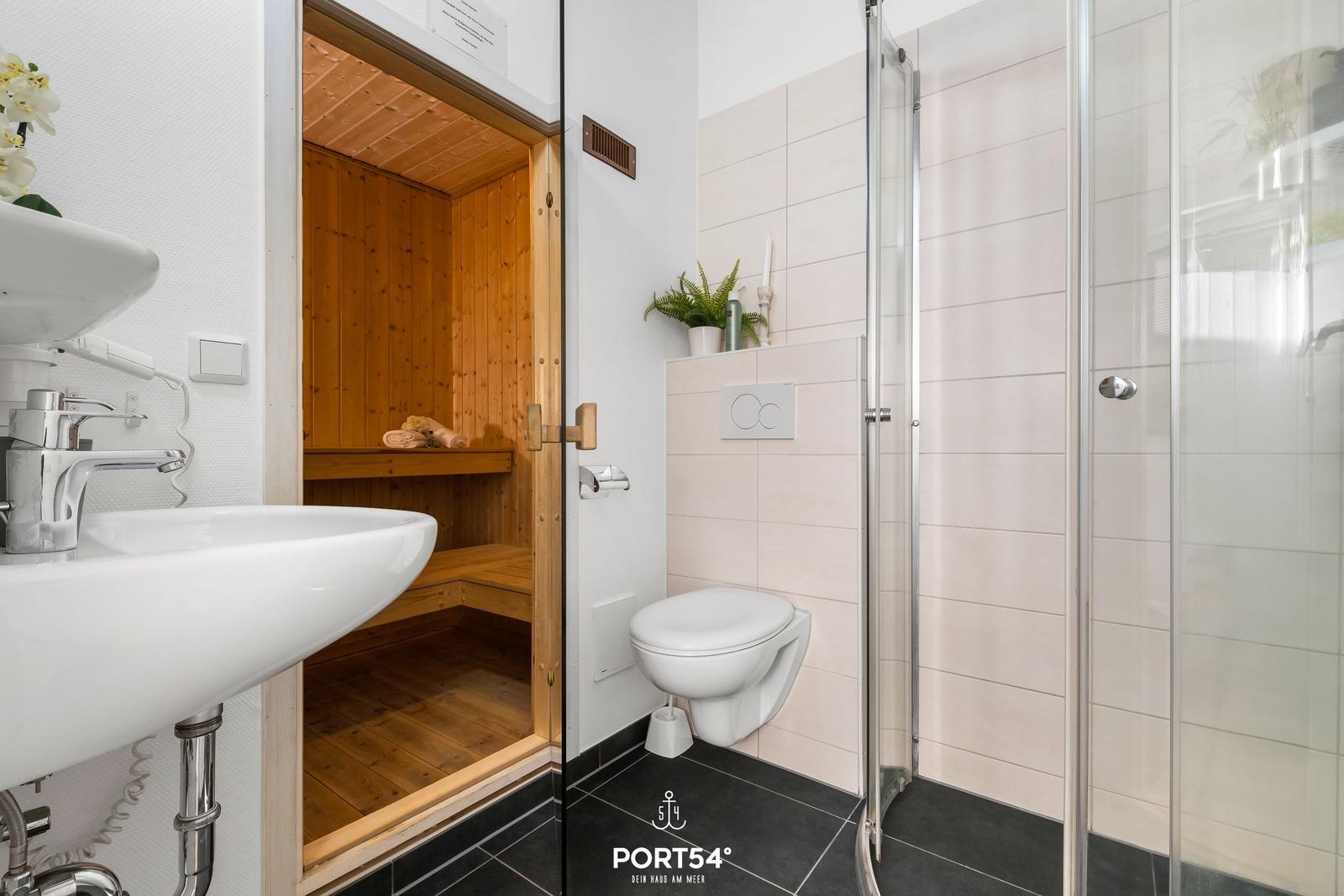 Badezimmer mit Dusche, Toilette und integrierter Sauna.