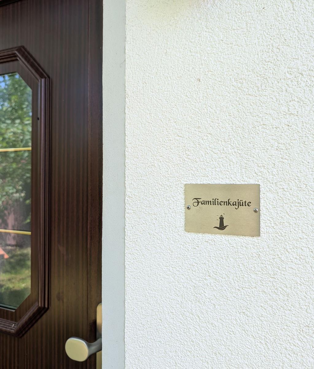 Schild an der Wand neben der Tür zeigt Familienkajüte mit Leuchtturm-Symbol.
